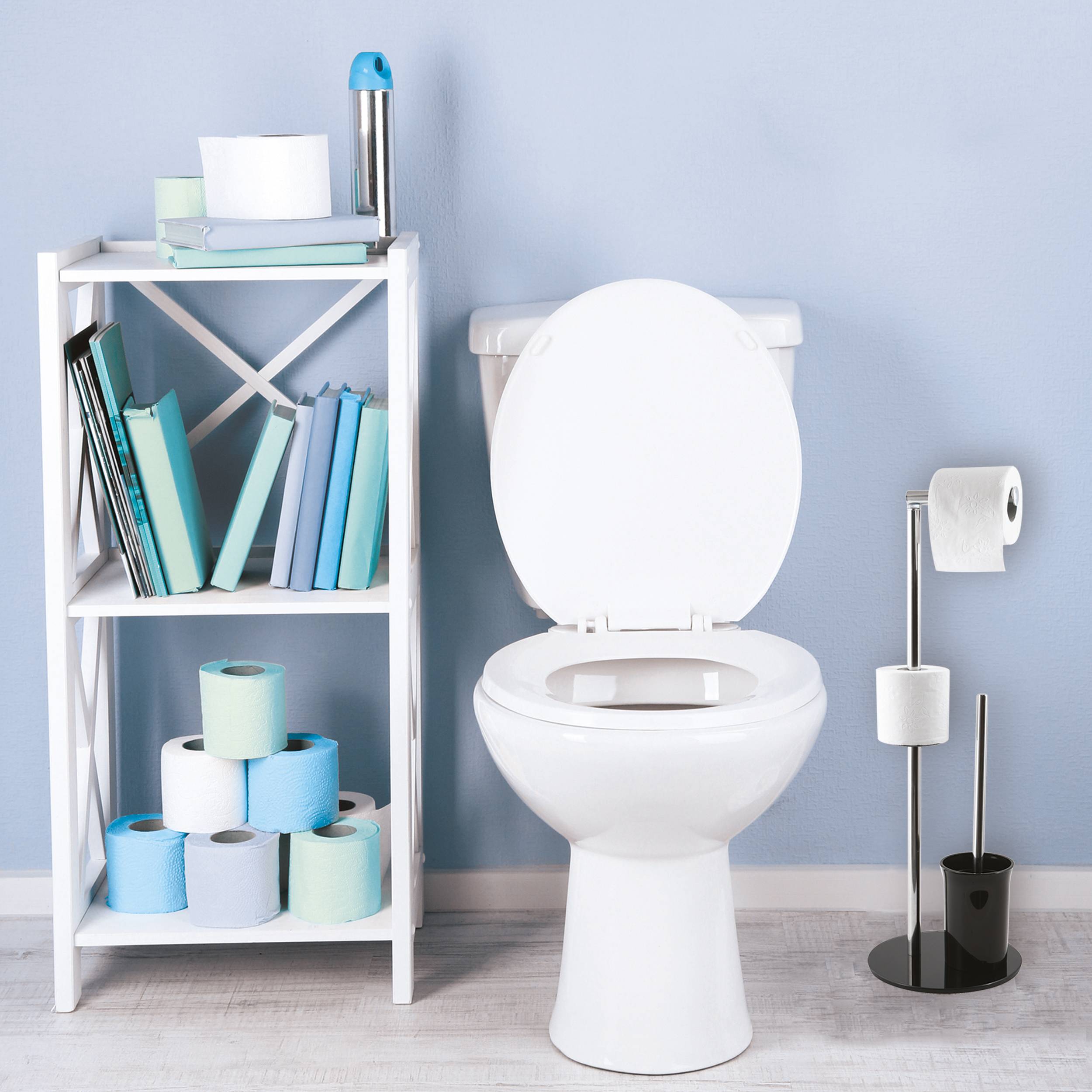Badezimmer mit Toilettenpapier-Vorräten auf einem Regalsystem neben einer Toilette und einem Toilettenpapierhalter.