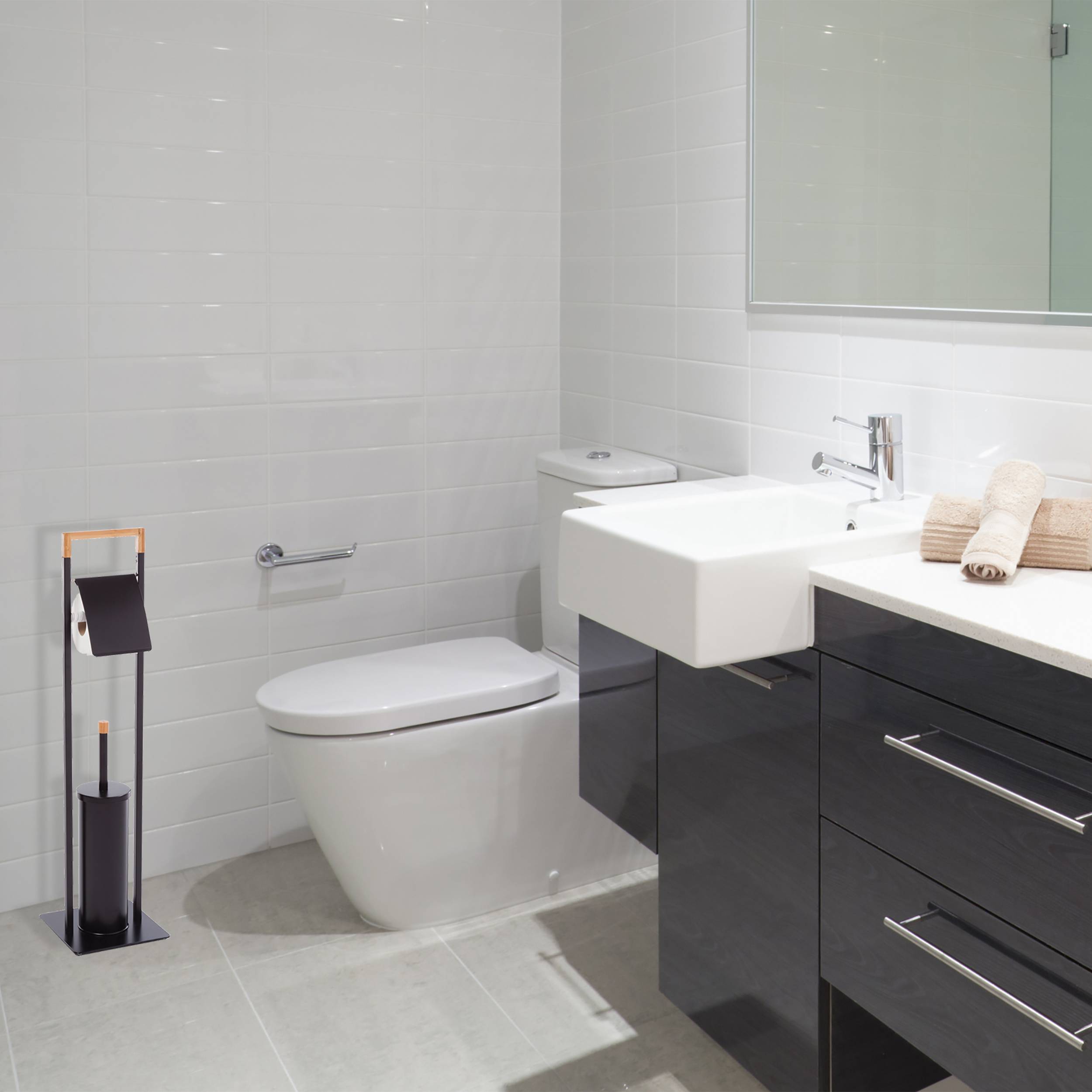 Modernes Badezimmer mit an der Wand montiertem Toilettenbecken, schwebendem Waschtischschrank, Spiegel und schwarzem Toilettenbürsten-Halter auf dem Boden.