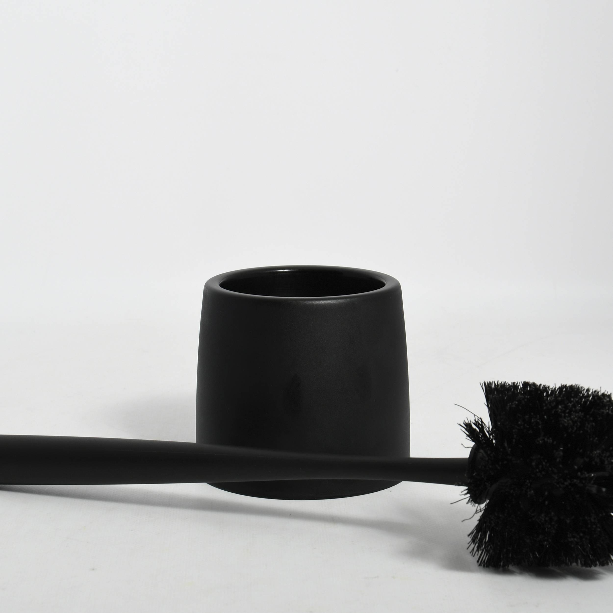 Schwarze Toilettenbürste mit Halter auf weißem Hintergrund, Bürstenkopf nach rechts und Griff sich über den Boden erstreckend.