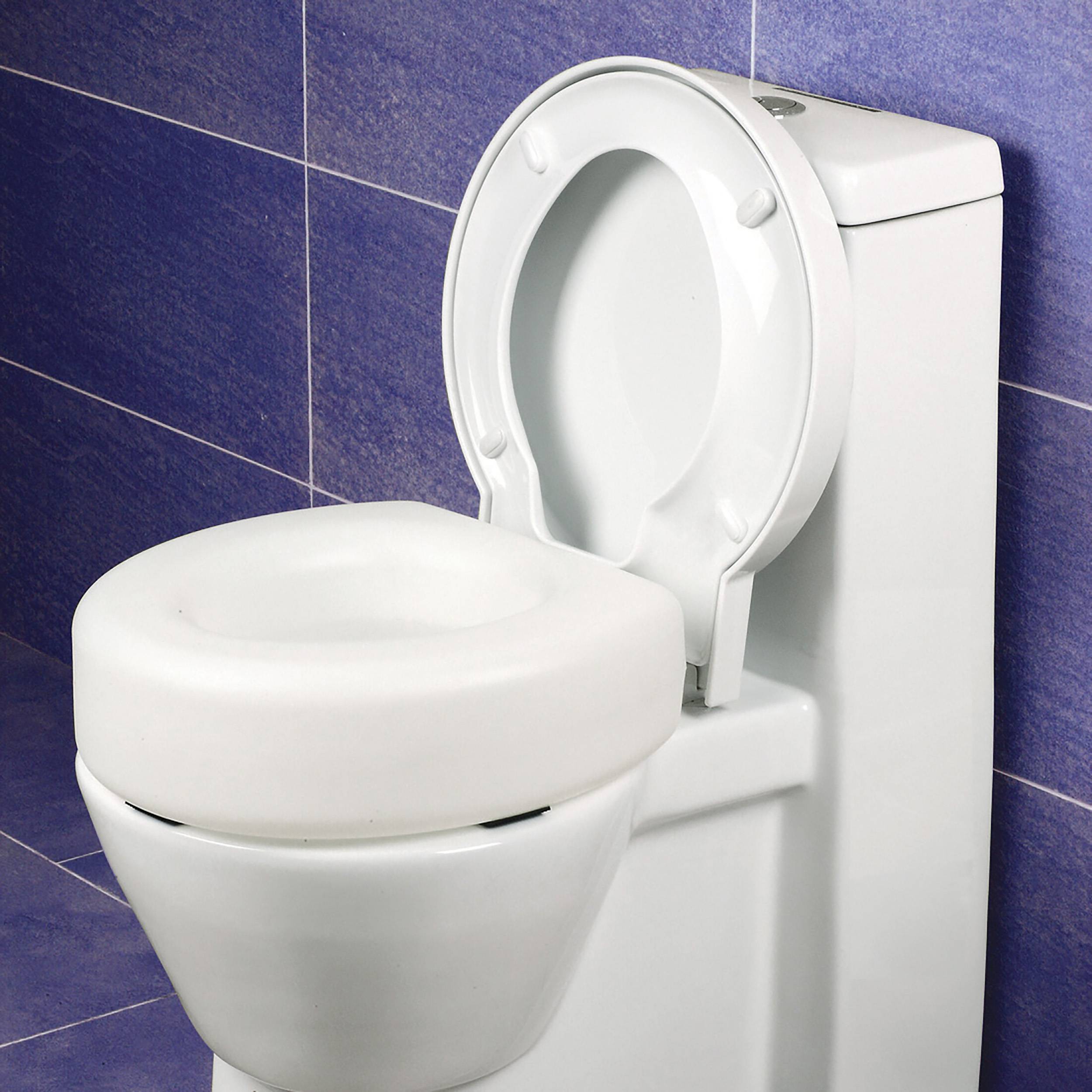 Weiße Toilette mit hochgeklapptem Sitz vor einer blaufliesigen Badezimmerwand.