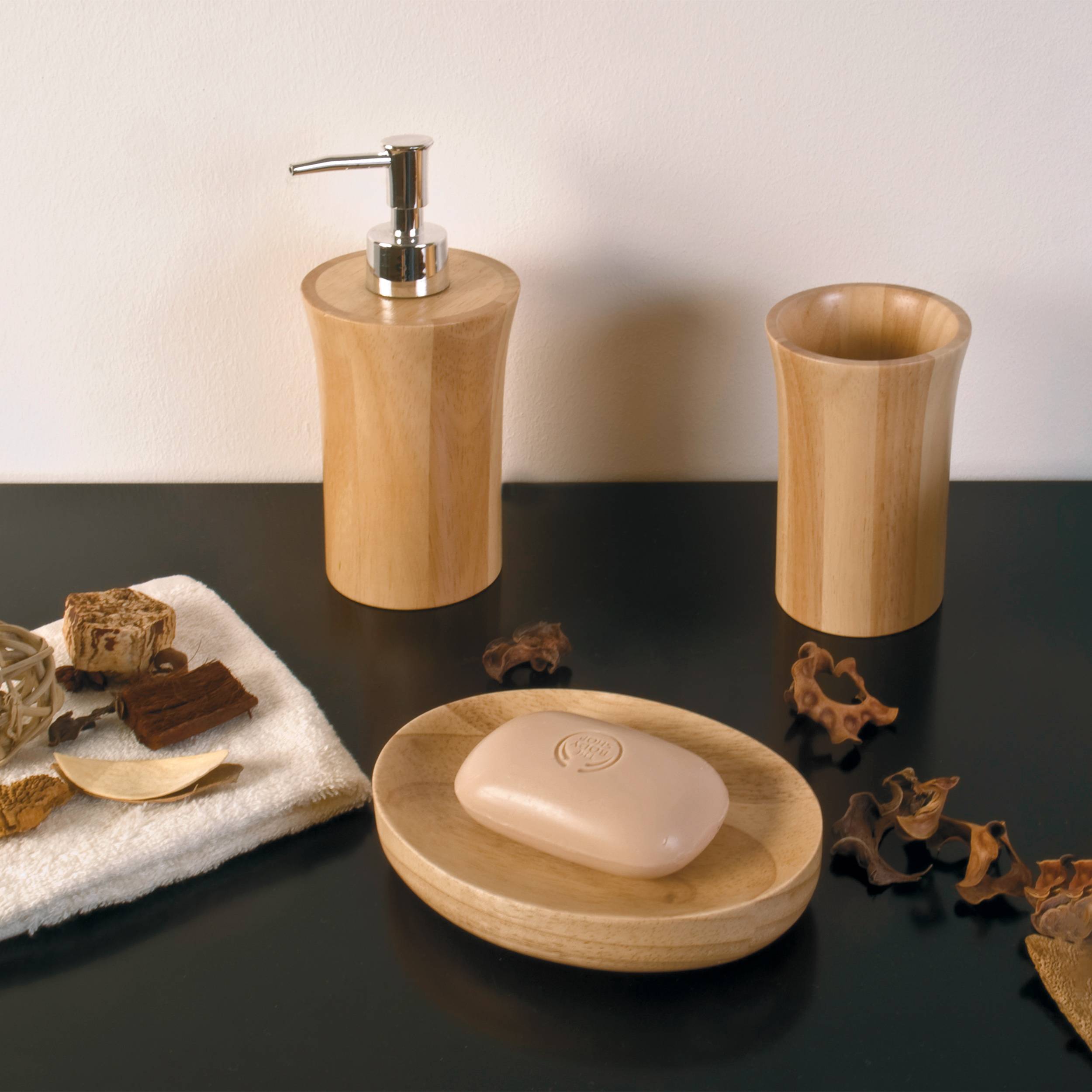 Badezimmer-Zubehörset mit hölzernem Seifenspender, Becher, Seifenschale mit Seife und natürlichem Luffaschwamm auf dunkler Oberfläche.