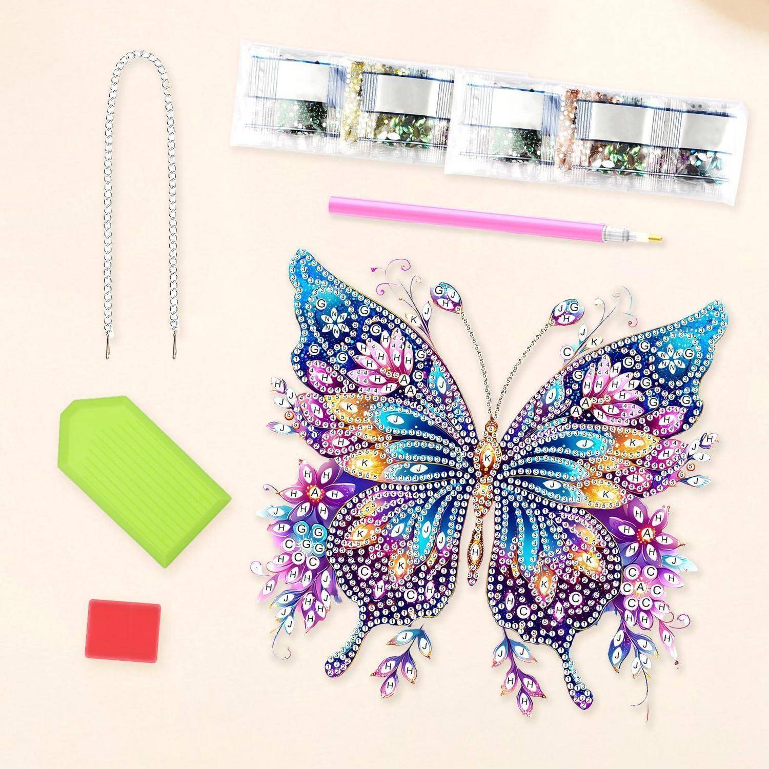 Diamant-Malerei-Set mit einem farbenfrohen Schmetterlingsdesign, Applikatorstift, Tabletts, Kette und Zubehörteilen auf hellem Hintergrund angeordnet.