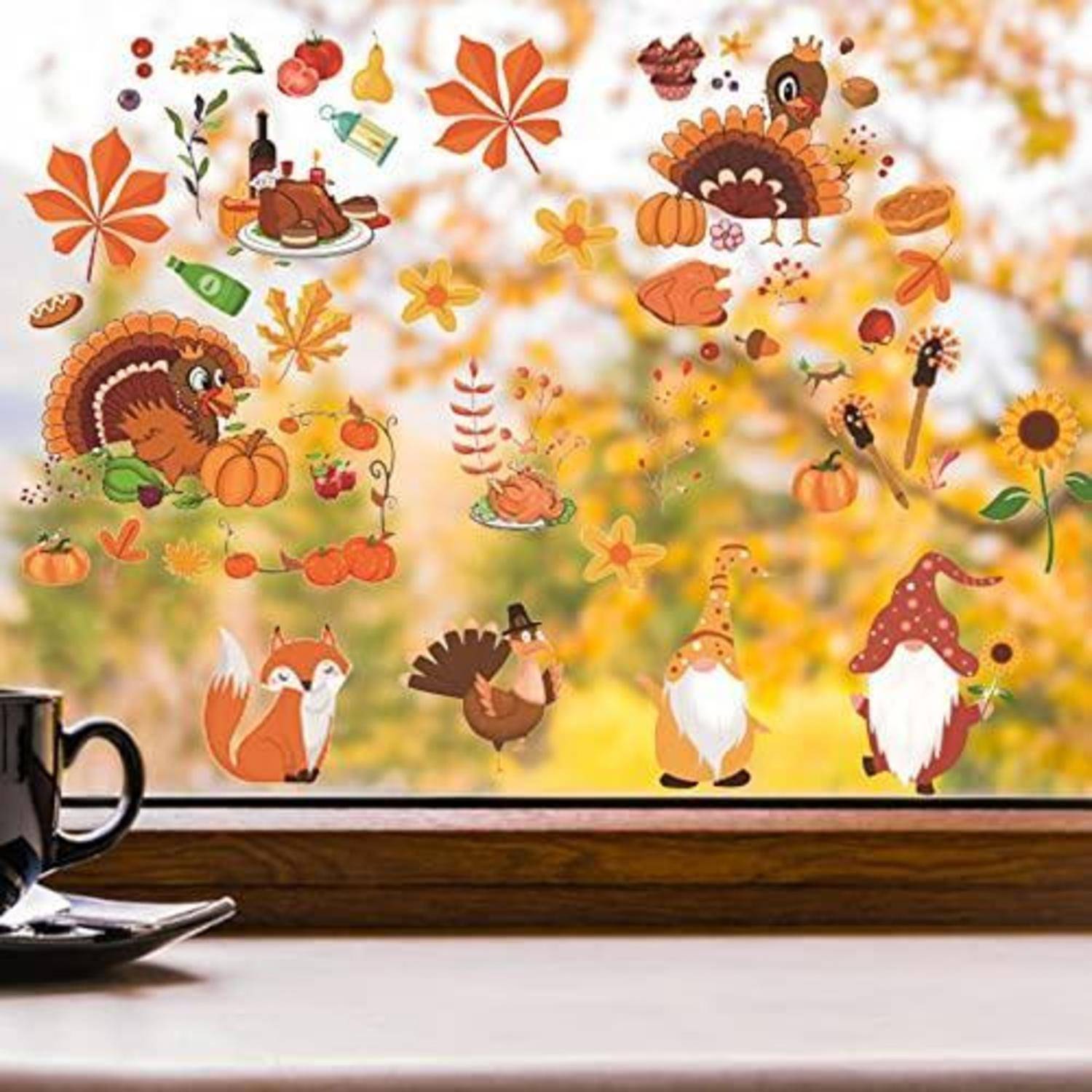 Fensterdekorationen im Herbststil mit Truthähnen, Fuchs, Kürbissen, Blättern und Thanksgiving-Aufklebern mit Speisen vor einem unscharfen Herbsthintergrund.
