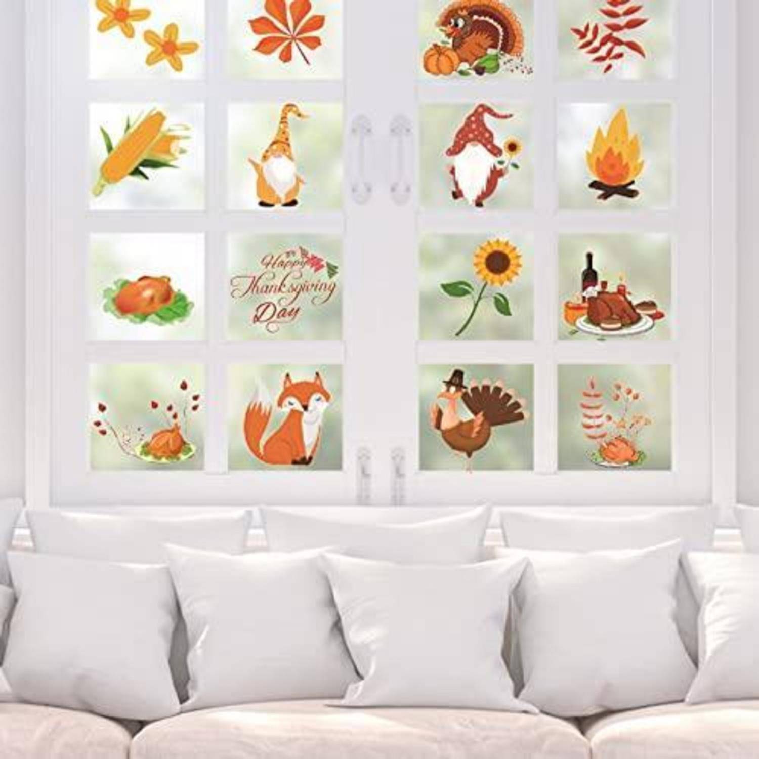 Fenster mit Thanksgiving-Aufklebern: Kürbisse, Truthahn, Mais, Sonnenblume, Blätter, Lagerfeuer und der Text „Happy Thanksgiving Day" über einem weißen Sofa.