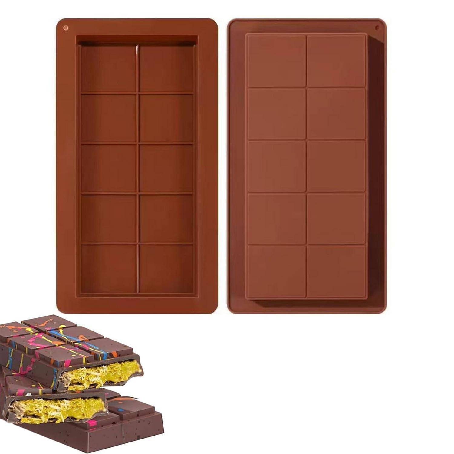 Zwei braune Schokoladenformen für Schokoladentafeln, die neben einer zerbrochenen Schokoladentafel mit bunter Füllung gezeigt werden, und demonstrieren die Formform und das fertige Bonbon.