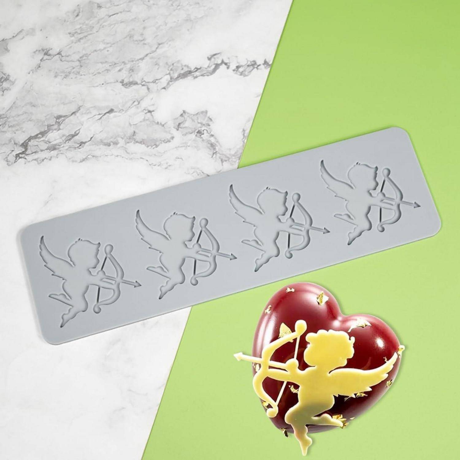 Silikonform mit vier Amoretten-Silhouetten über einer fertiggestellten glänzenden herzförmigen Dekoration mit einer Amoretten-Figur.