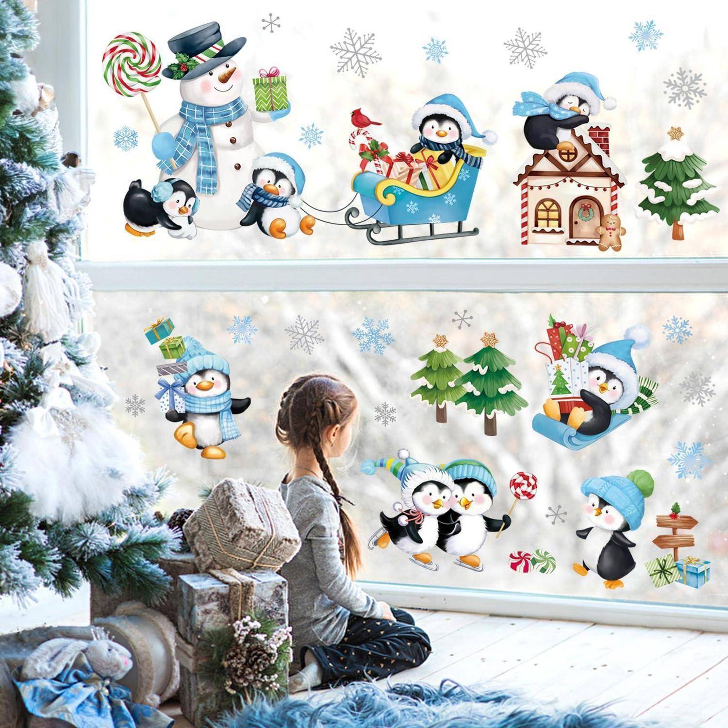 Kind schaut sich ein Winter-Wandgemälde mit Pinguinen, Schneemann, Schlitten und Weihnachtsgeschenken mit Schneeflocken und Bäumen an.