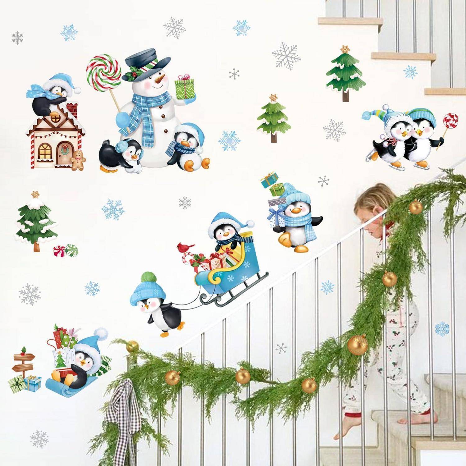 Kind, das eine Treppe mit Weihnachtsgirlanden und Ornamenten hinuntergeht, umgeben von verspielten Pinguin- und Schneemann-Wandaufklebern im Feststil.