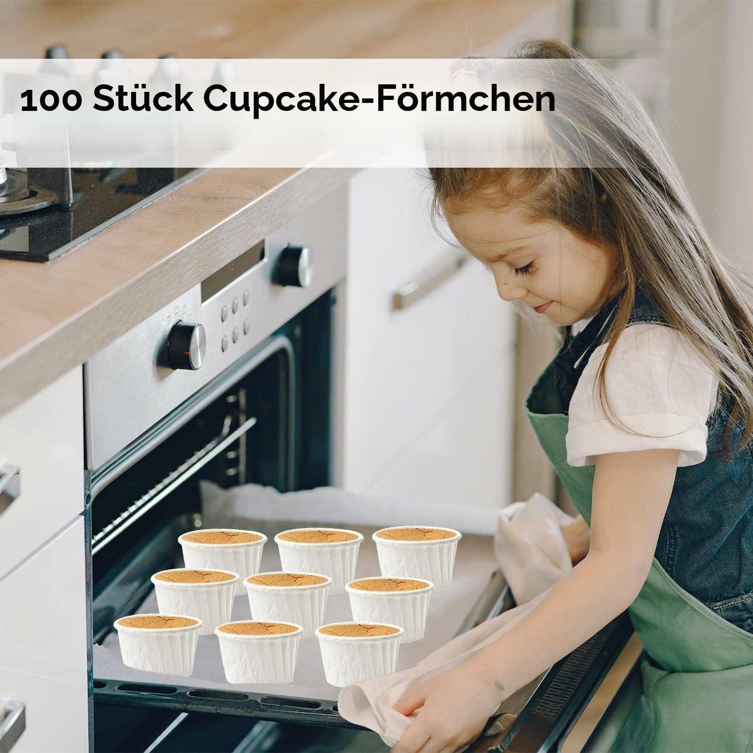 Mädchen in der Küche, das ein Tablett mit Cupcakes in den Ofen schiebt; der Text lautet „100 Stück Cupcake-Formchen".