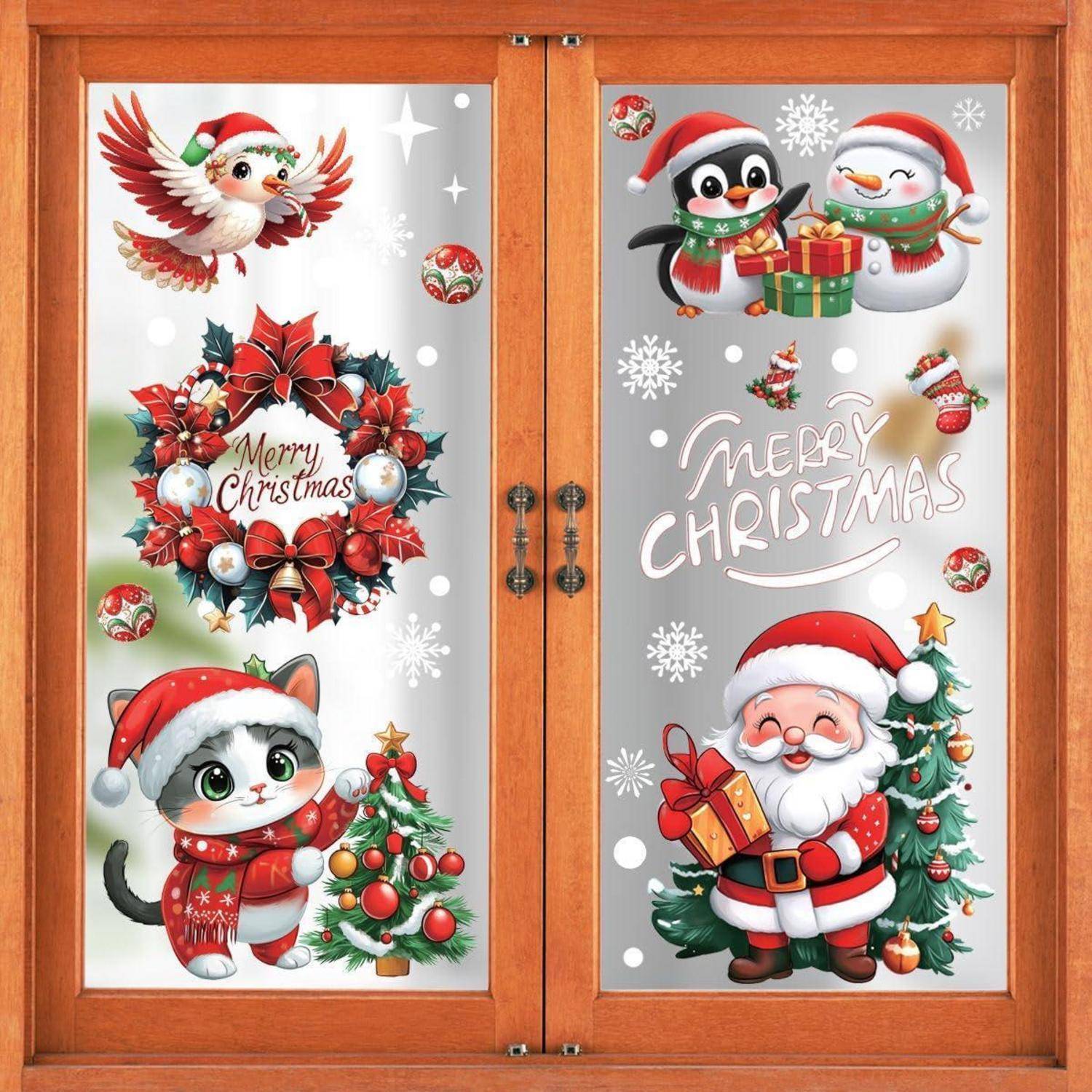 Weihnachtsthematische Fensteraufkleber mit einem Kranz, auf dem „Frohe Weihnachten" steht, dem Weihnachtsmann, Pinguinen, einem Kätzchen und festlichen Ornamenten auf Mattglas.