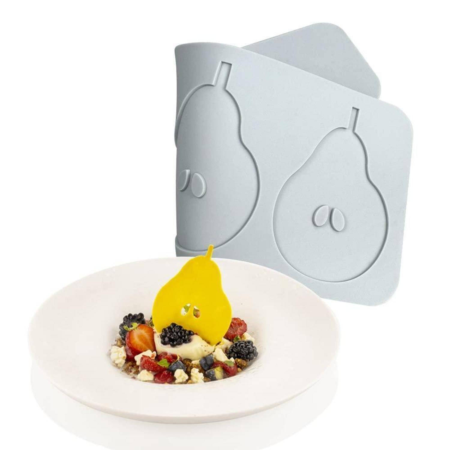 Weißer Teller mit einem Dessert, das mit einer gelben birnenförmigen Garnitur gekrönt ist, vor zwei silbernen birnenförmigen Formen oder Verpackungsdisplays.