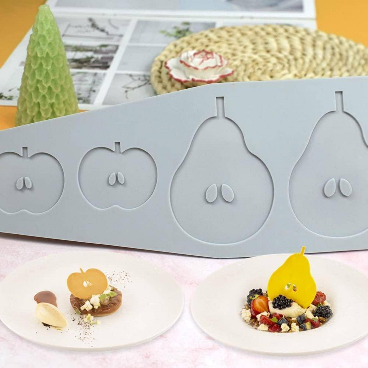 Grauförmige obst- oder tablett-form, die mit plattierten miniatur-desserts angeordnet ist, die mit birnen- und apfelgarnituren auf weißen tellern garniert sind.