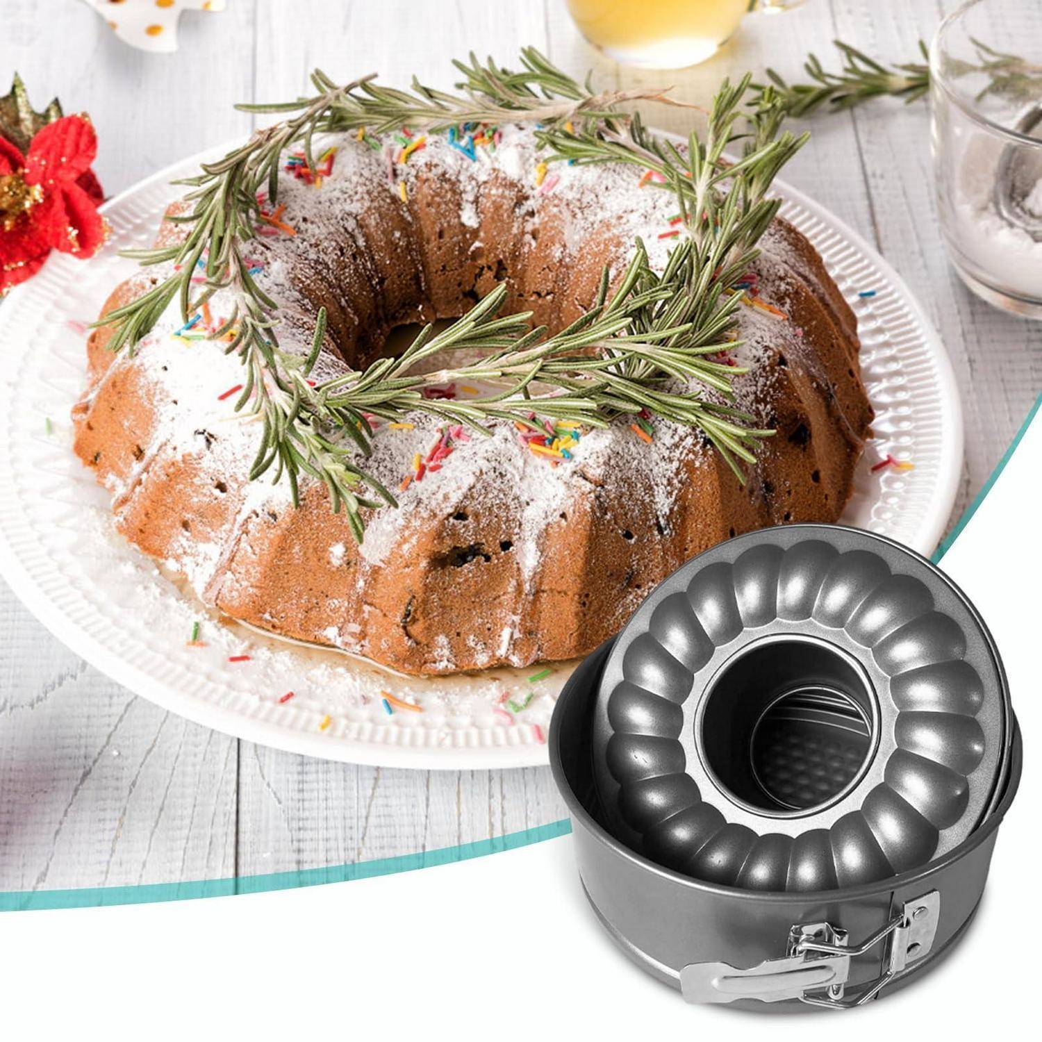 Gugelhupf auf einem Teller mit Rosmarin-Garnierung, neben einer antihaftbeschichteten Springform-Gugelpfanne.