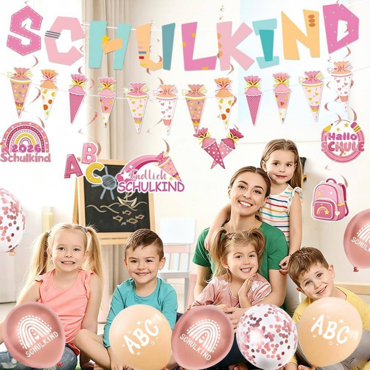 Lächelnde Lehrerin und vier Kinder posieren in einem dekorierten Klassenzimmer zu einer Schulanfangsfeier und halten Luftballons mit den Aufschriften "ABC"" und ""Schulkind"".