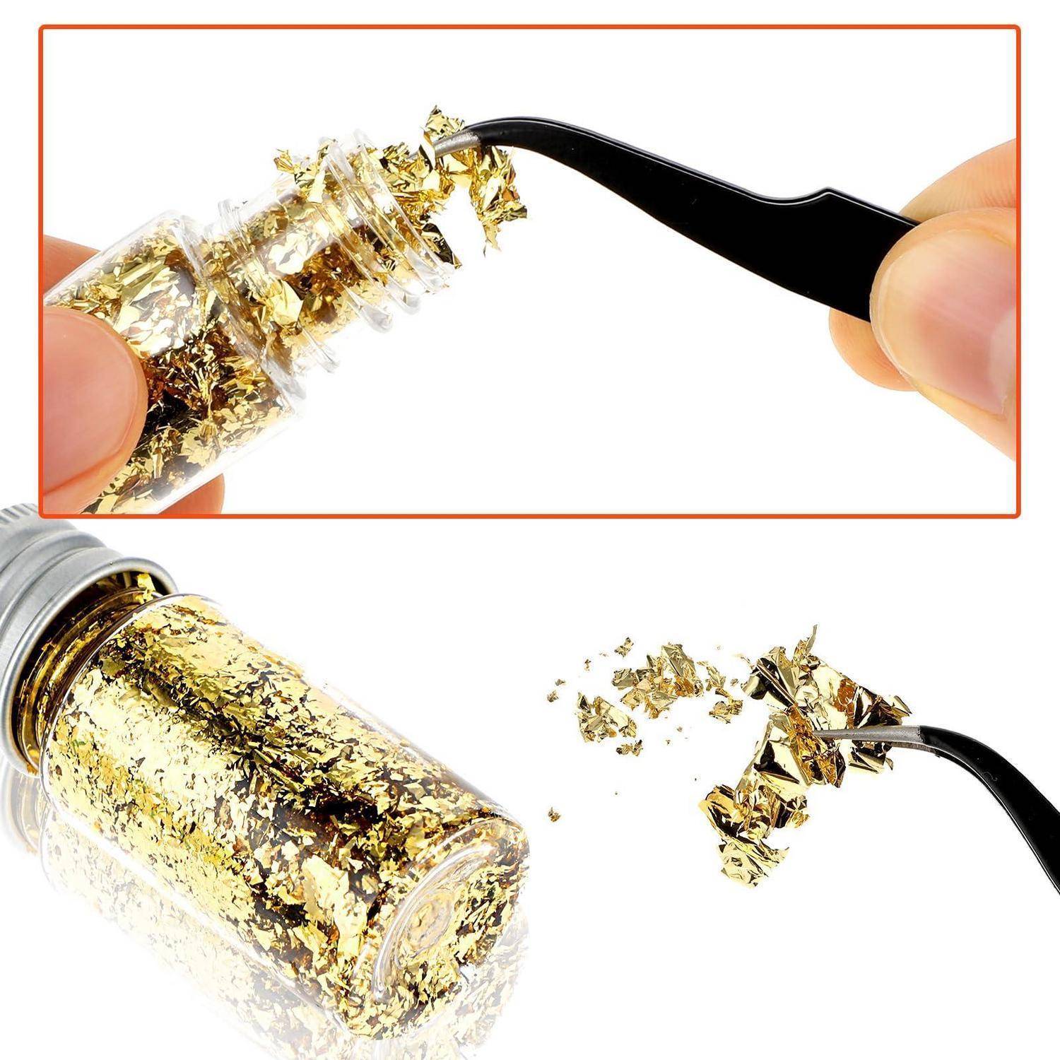 Nahaufnahme einer Pinzette, die Goldblättchen aus einem Fläschchen entfernt, mit einer größeren Flasche Goldblattflöckchen darunter.