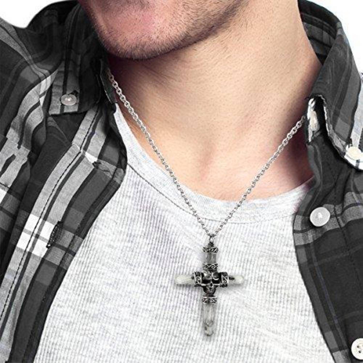 Nahaufnahme eines Mannes, der einen silbernen Totenkopf-Kreuz-Anhänger über einem weißen Hemd und einem karierten Hemd trägt.
