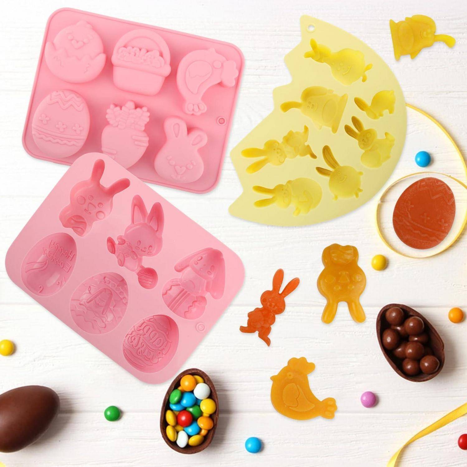 Osterdesign-Silikonformen und kleine Schokoladeneier mit Hase- und Kükenformen, gezeigt auf einem weißen Tisch mit verstreutem Bonbon.