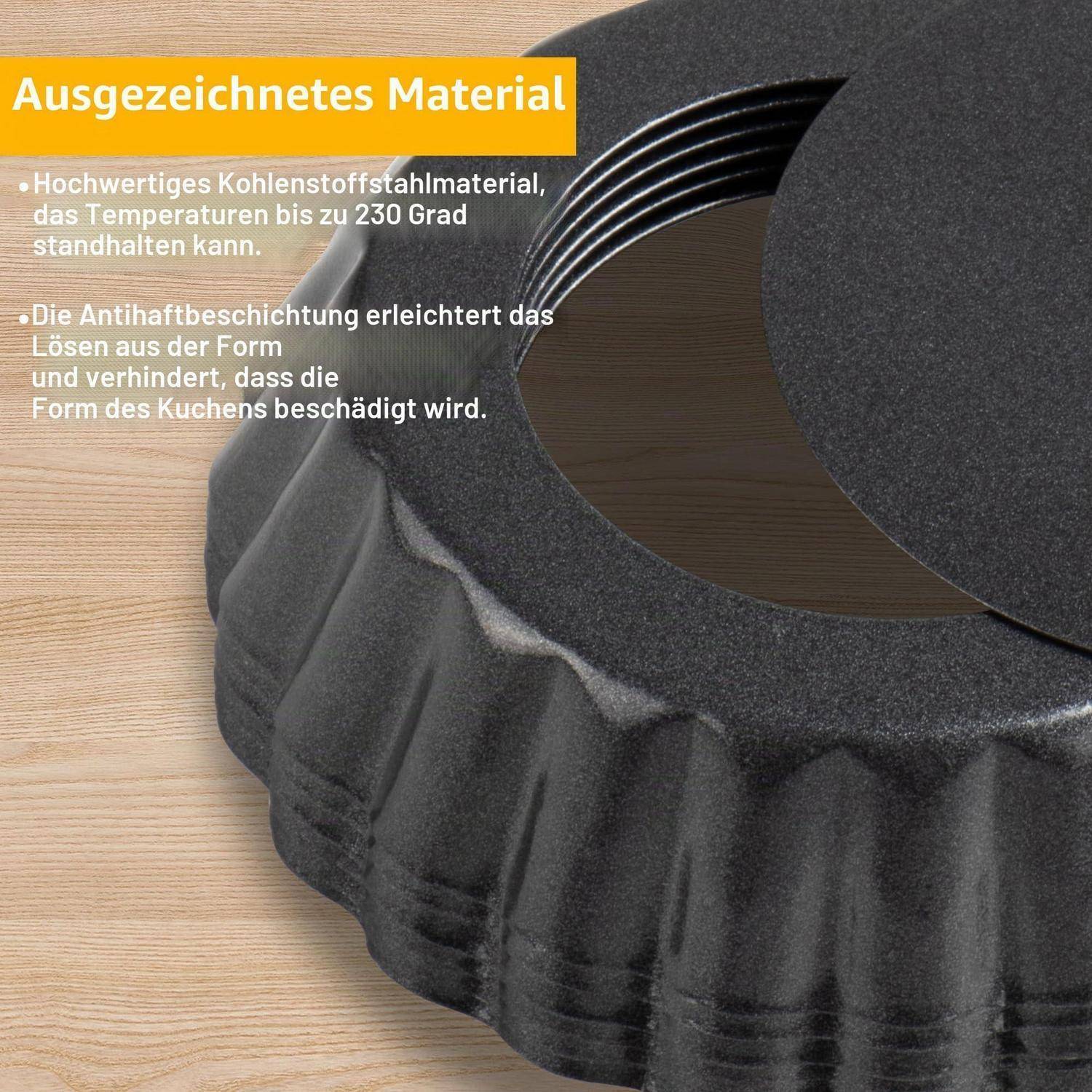 Schwarze gerillte Kuchenform mit abnehmbarem Boden auf Holzoberfläche, beschriftet auf Deutsch mit „Ausgezeichnetes Material"; Text besagt Kohlenstoffstahl, hitzebeständig bis 230°C, antihaftbeschichtet.