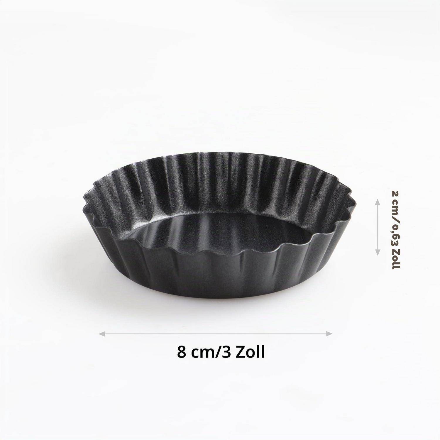 Schwarze gerillte Tarteform, gekennzeichnet mit 8 cm (3 Zoll) Breite und 2 cm (0,63 Zoll) Höhe, auf weißem Hintergrund gezeigt.
