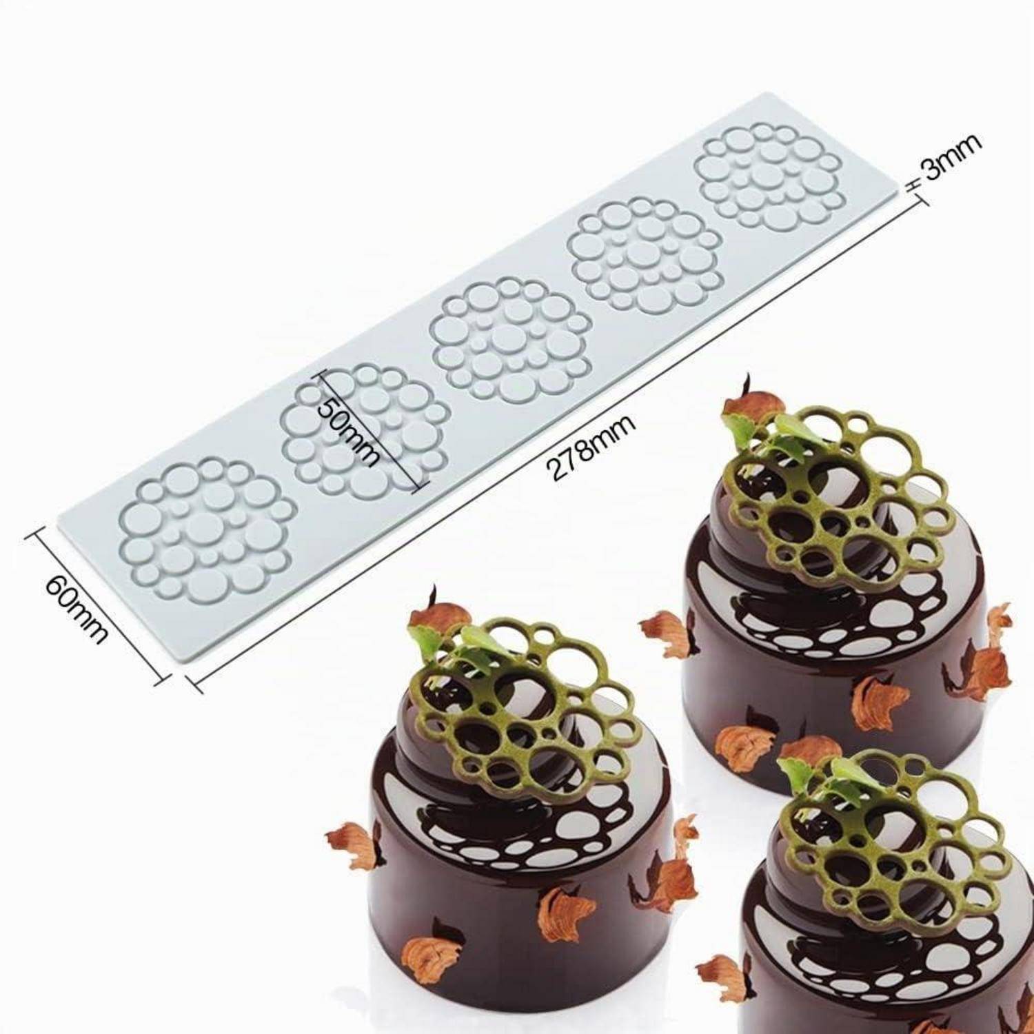 Silikonform zum Herstellen von blütenförmigen Spitzenschokoladen-Dekorationen, gezeigt mit fertigen Stücken auf kleinen Kuchen; Form misst 278 mm × 60 mm und ist 3 mm dick.