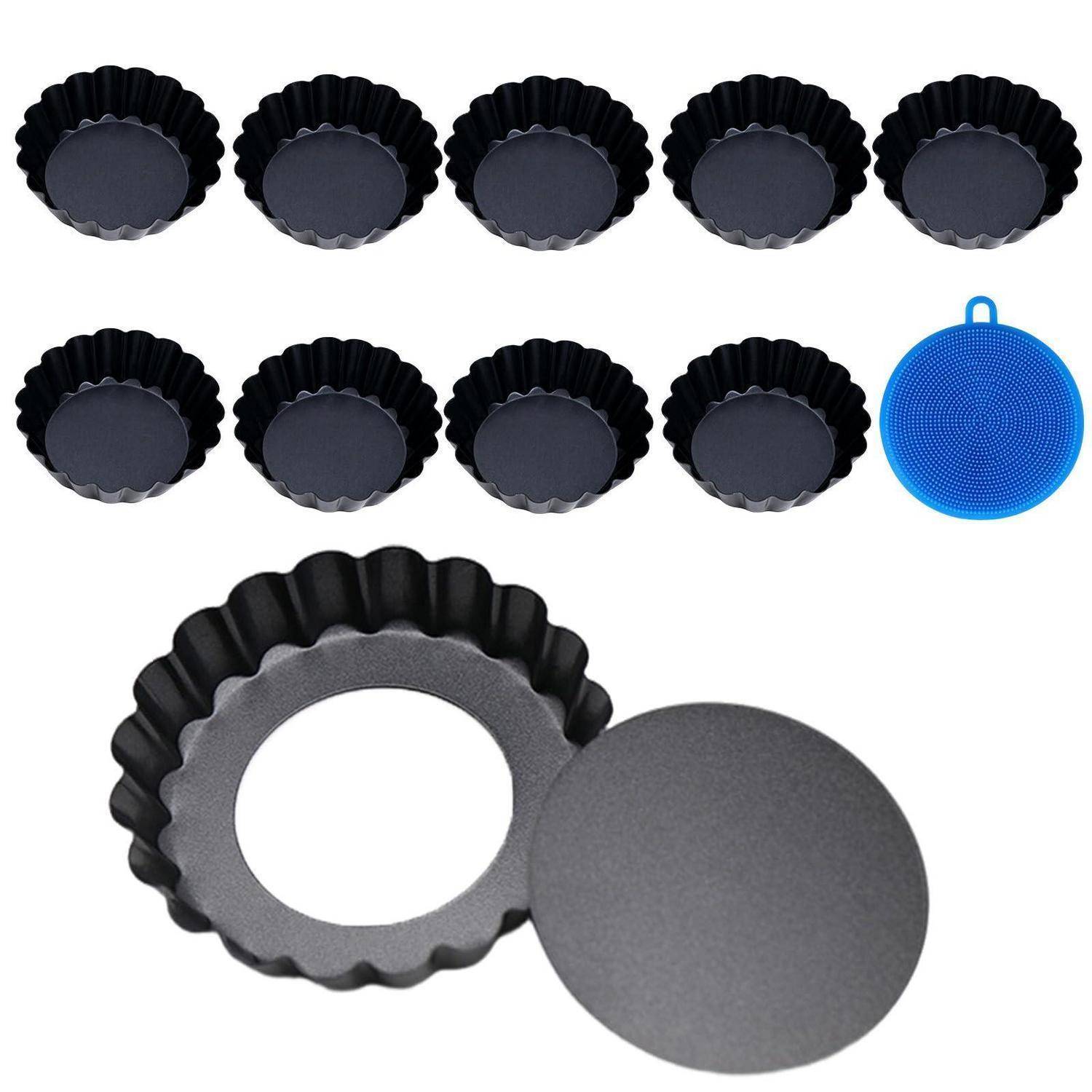 Satz schwarzer gerillter Mini-Tortenformen und eine runde blaue Silikonmatte, mit zwei Formen in Nahaufnahme und eine Form mit abnehmbarem Boden.