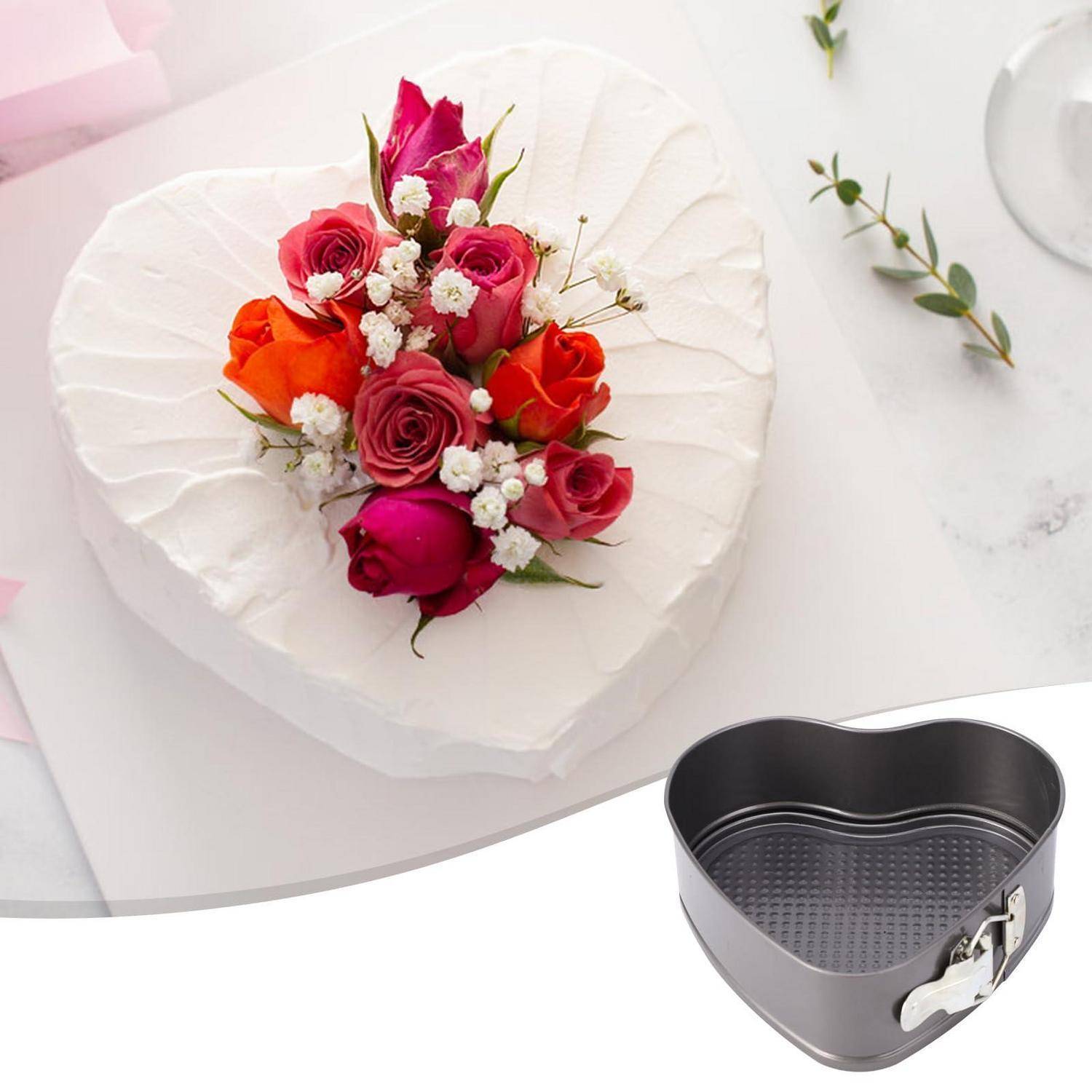 Herzförmige Backform, dargestellt mit einem fertigen herzförmigen Kuchen, der mit Rosen verziert ist, was auf eine Backform für besondere Anlässe hinweist.