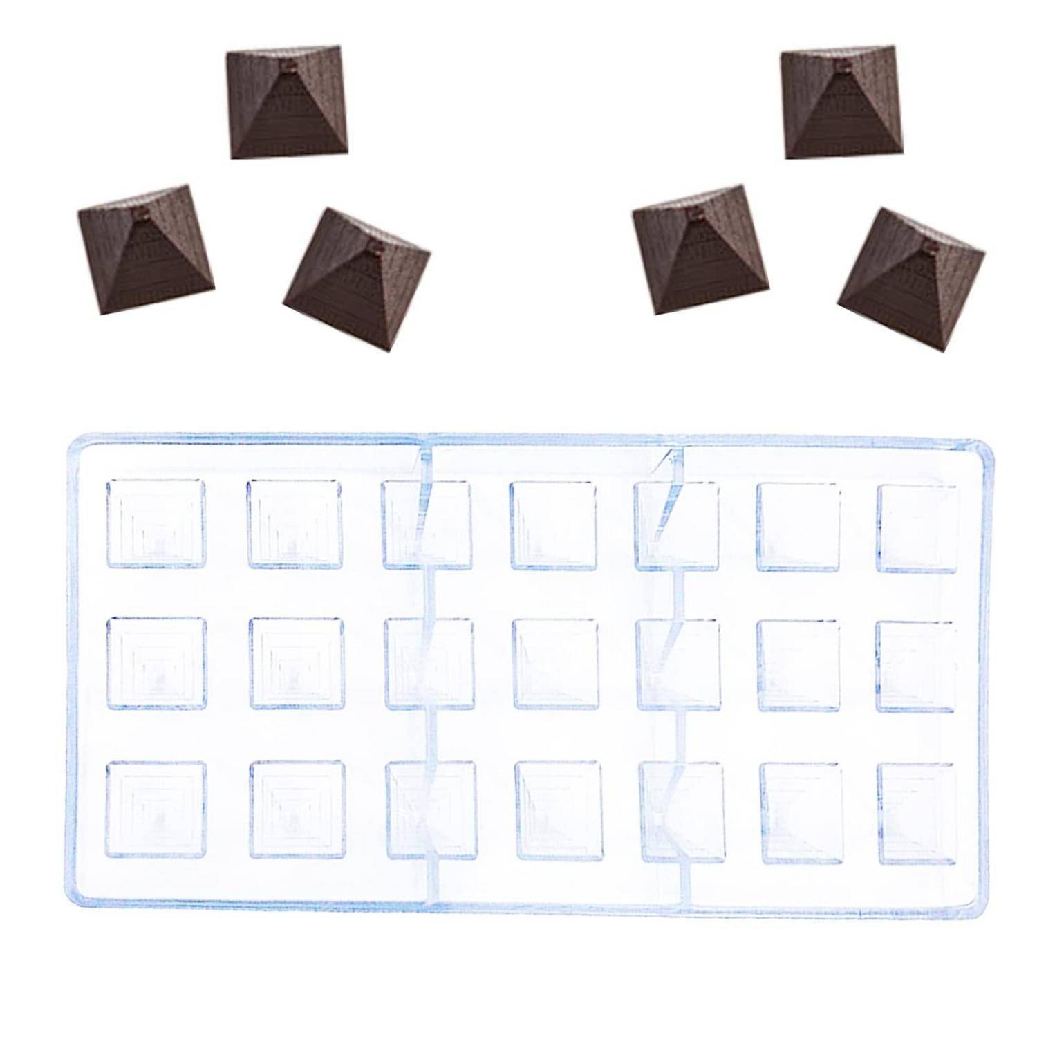 Klare Kunststoff-Gussform mit 12 quadratischen Vertiefungen und fünf kleine braune pyramidenförmige Stücke darüber, was auf eine Schokoladen- oder Bonbonform hindeutet.