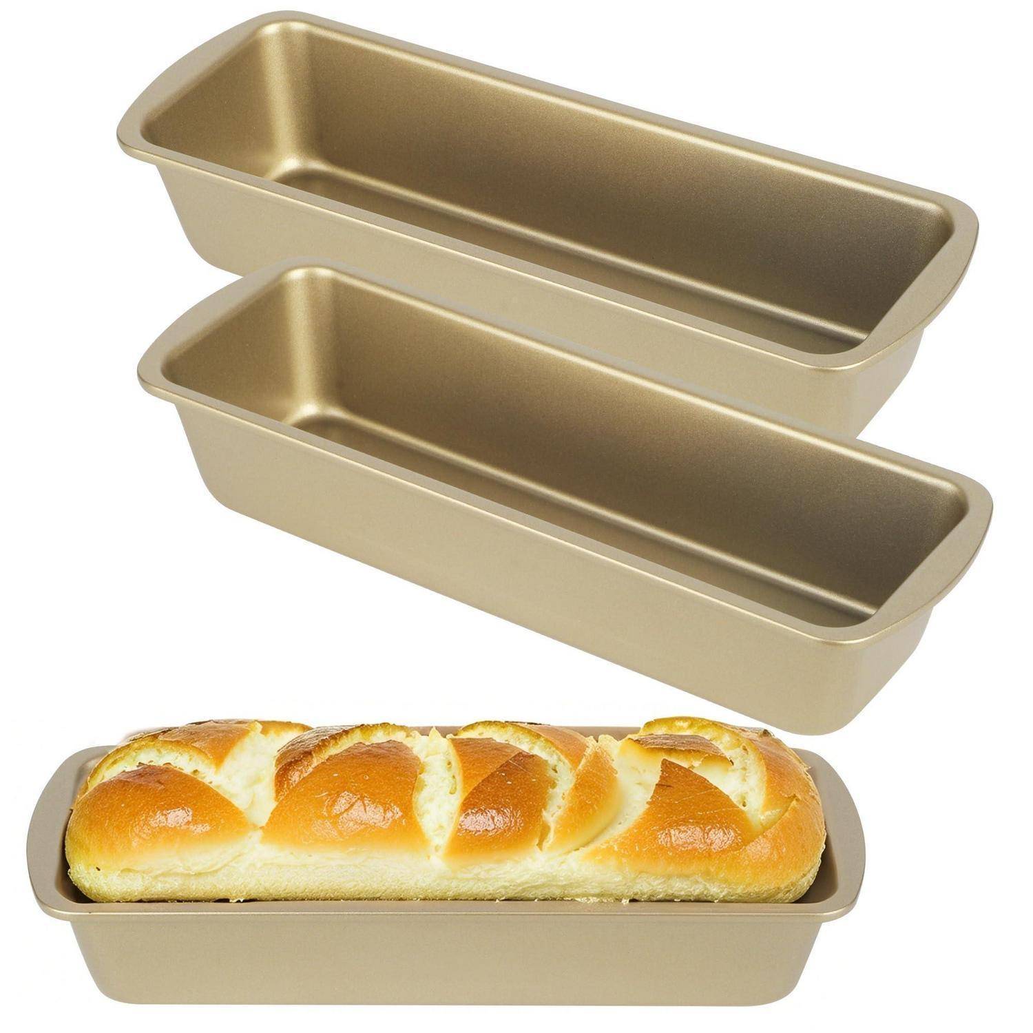 Zwei goldfarbene Kastenformen übereinandergestapelt über einem gebackenen Laib in einer passenden Form, was zeigt, dass die Formen zum Brotbacken verwendet werden.