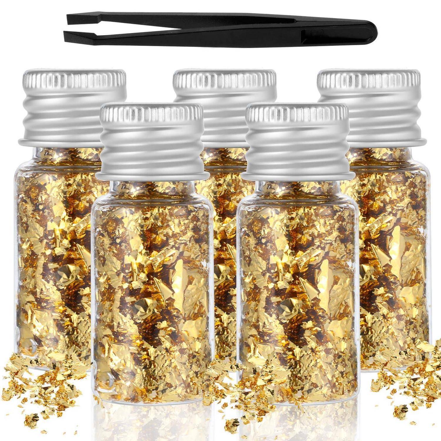 Fünf kleine Gläser mit Goldfolien-Flocken mit silbernen Verschlüssen und schwarzen Pinzetten oben, gezeigt als Handwerk- oder Nagelkunst-Set.