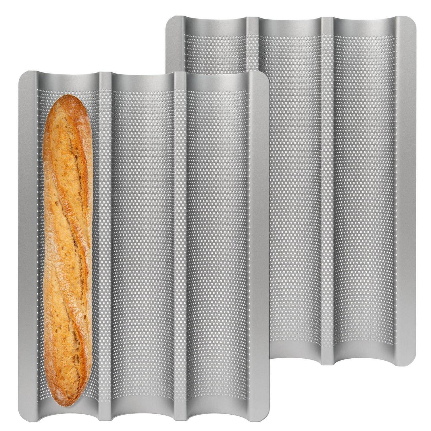 Zwei gewellte silberne Metallbackformen, eine mit einem langen Brot gefüllt, auf weißem Hintergrund dargestellt.