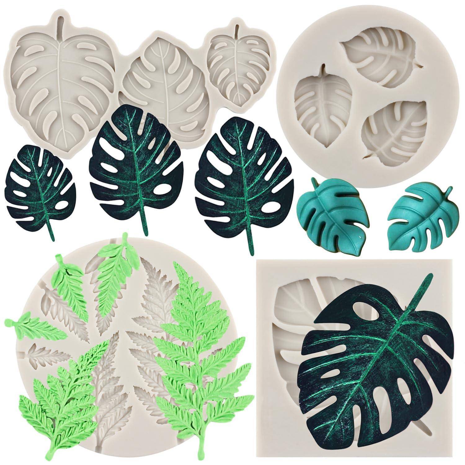 Assortierte blattförmige Silikonformen und fertige Monstera-ähnliche Harz- oder Tonblätter in Grau, Grün und Blaugrün auf weißem Hintergrund.