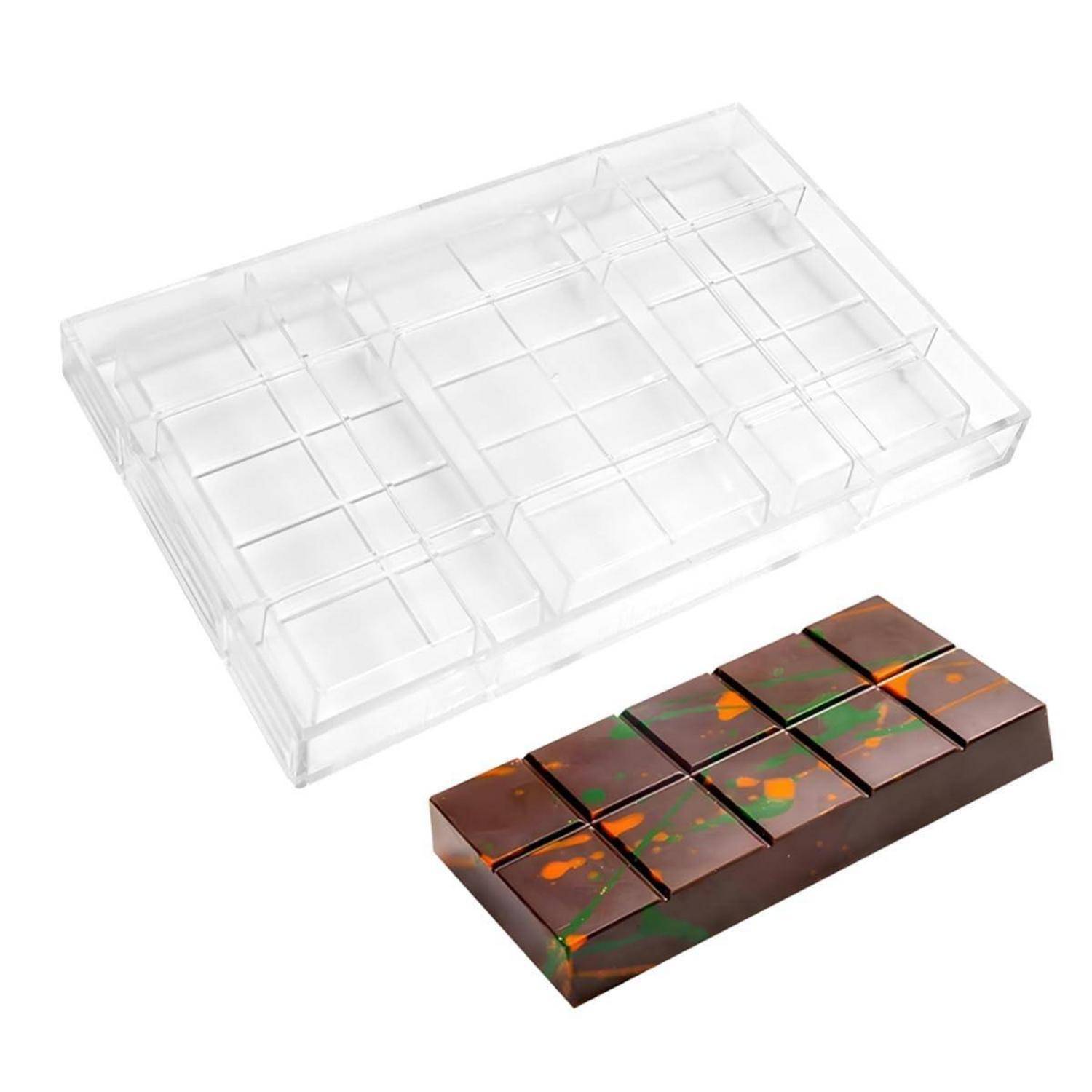Transparente Kunststoffform über einem fertigen segmentierten Schokoladeriegel mit orange- und grünfarbenen Wirbeln.