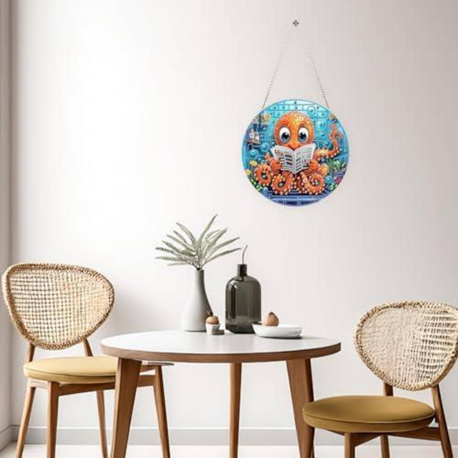 Minimalistischer Essecke mit zwei geflochtenen Stühlen, rundem Tisch und einer Vase; eine farbenfrohe Kraken-Wandkunst hängt darüber.