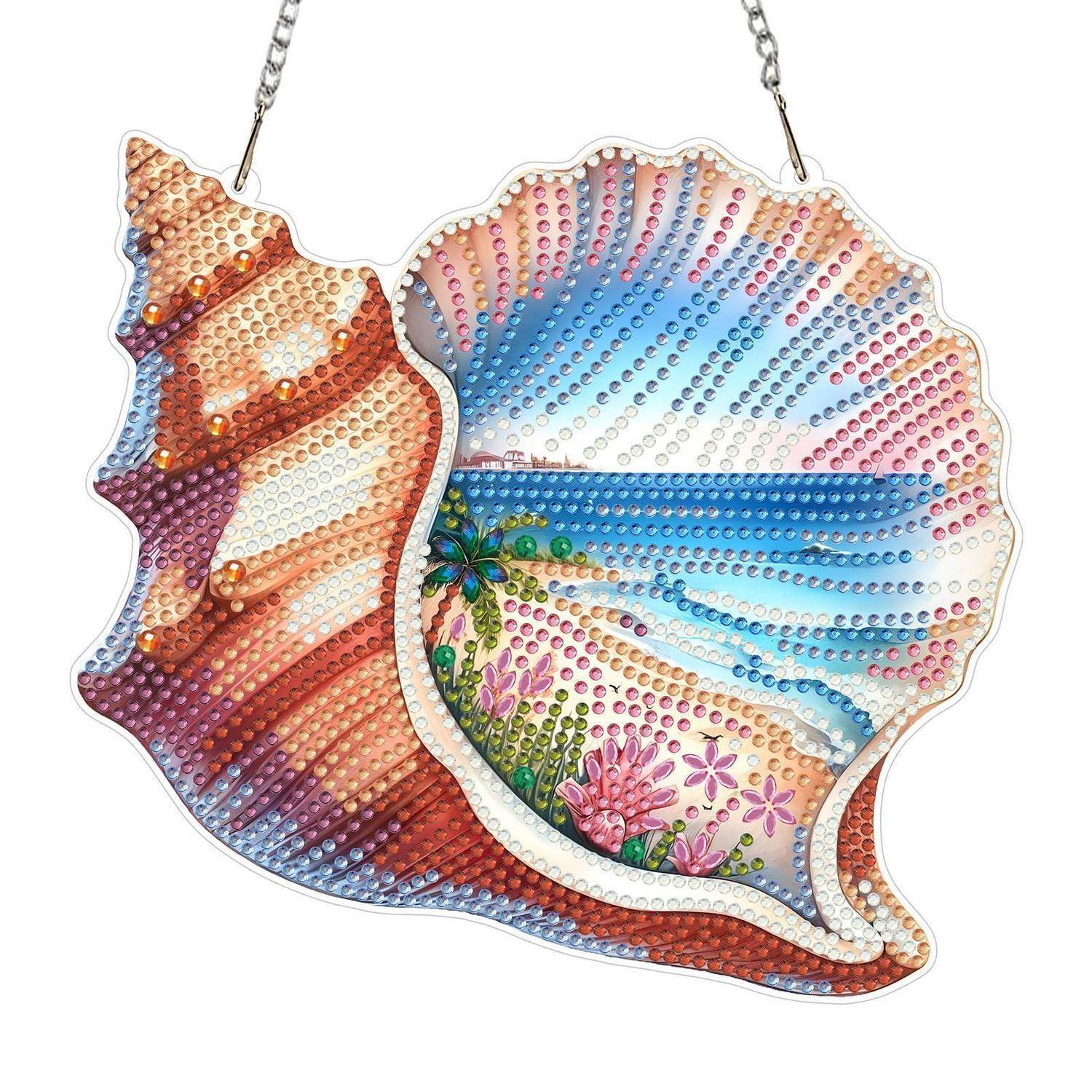 Zwei schillernde muschelförmige Hängeketten mit perlenbesetzten, bemalten Strand- und Sonnenuntergangsmotiven auf weißem Hintergrund.
