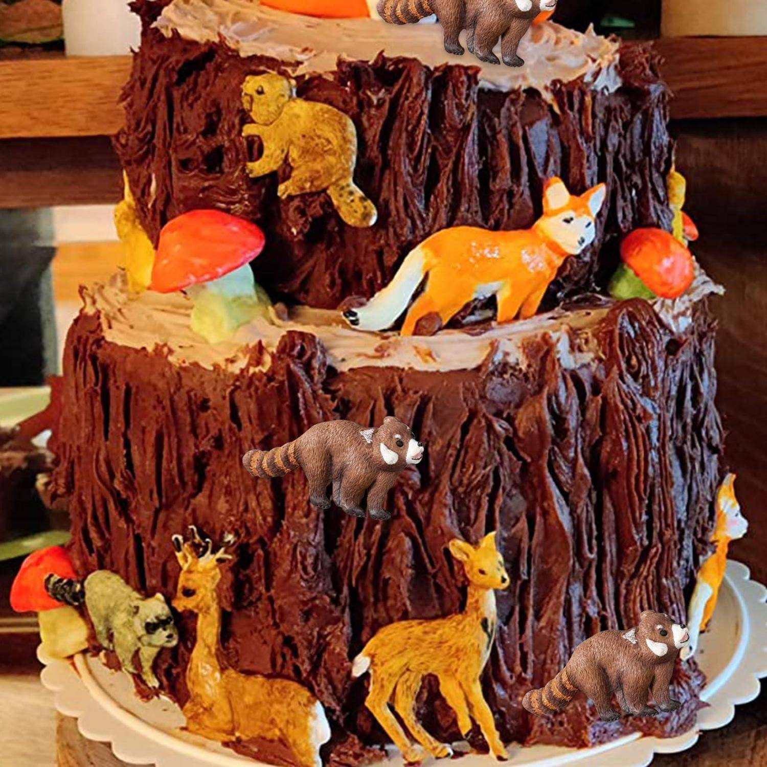 Dreistöckige Schokoladentorte, verziert mit Tierfiguren, darunter ein Fuchs, ein Reh, ein Bär und eine Giraffe, sowie rote Pilzornamente.
