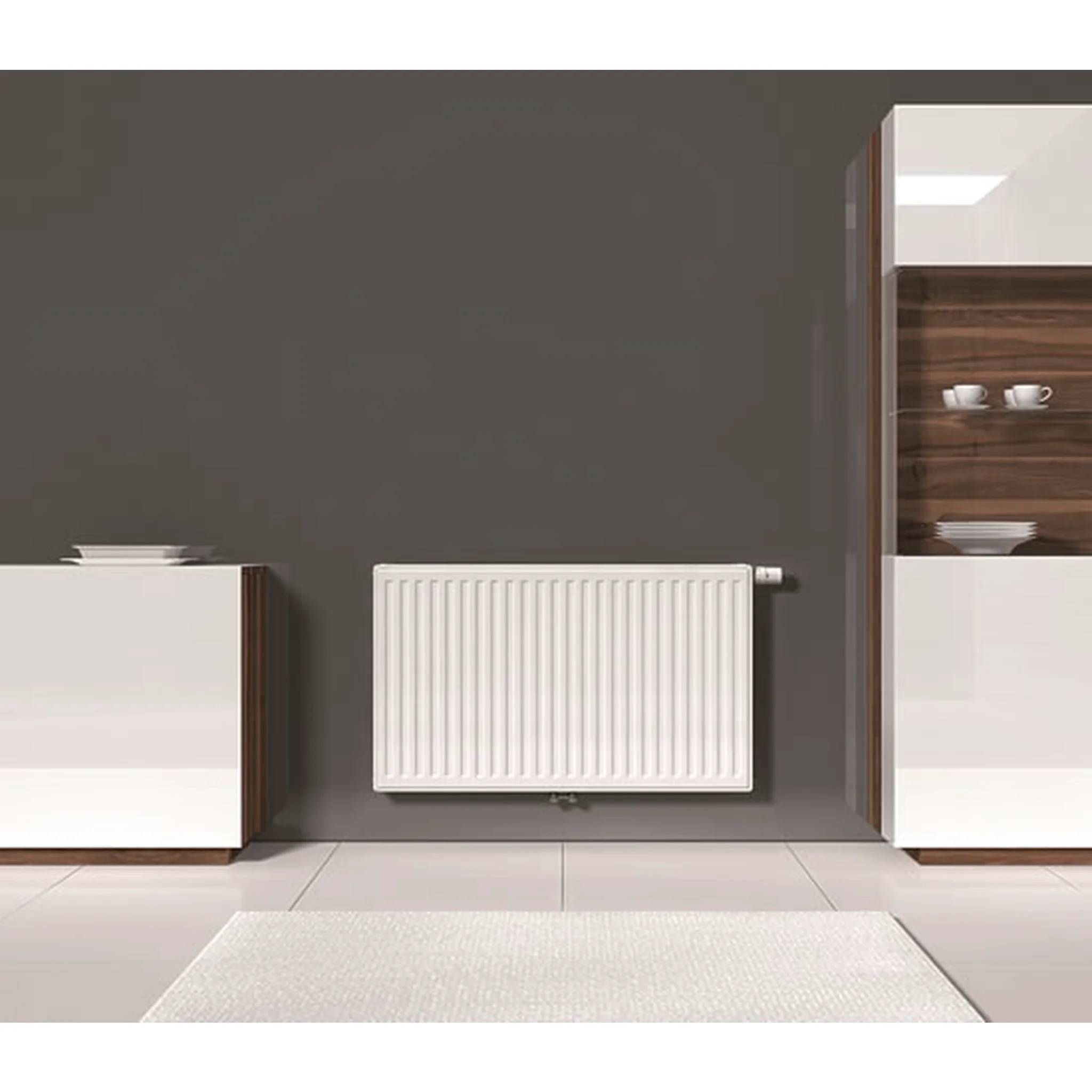 Modernes Interieur mit einem weißen wandmontierten Heizkörper, der in der Mitte einer dunkelgrauen Wand zwischen zwei weißen Schränken angebracht ist.