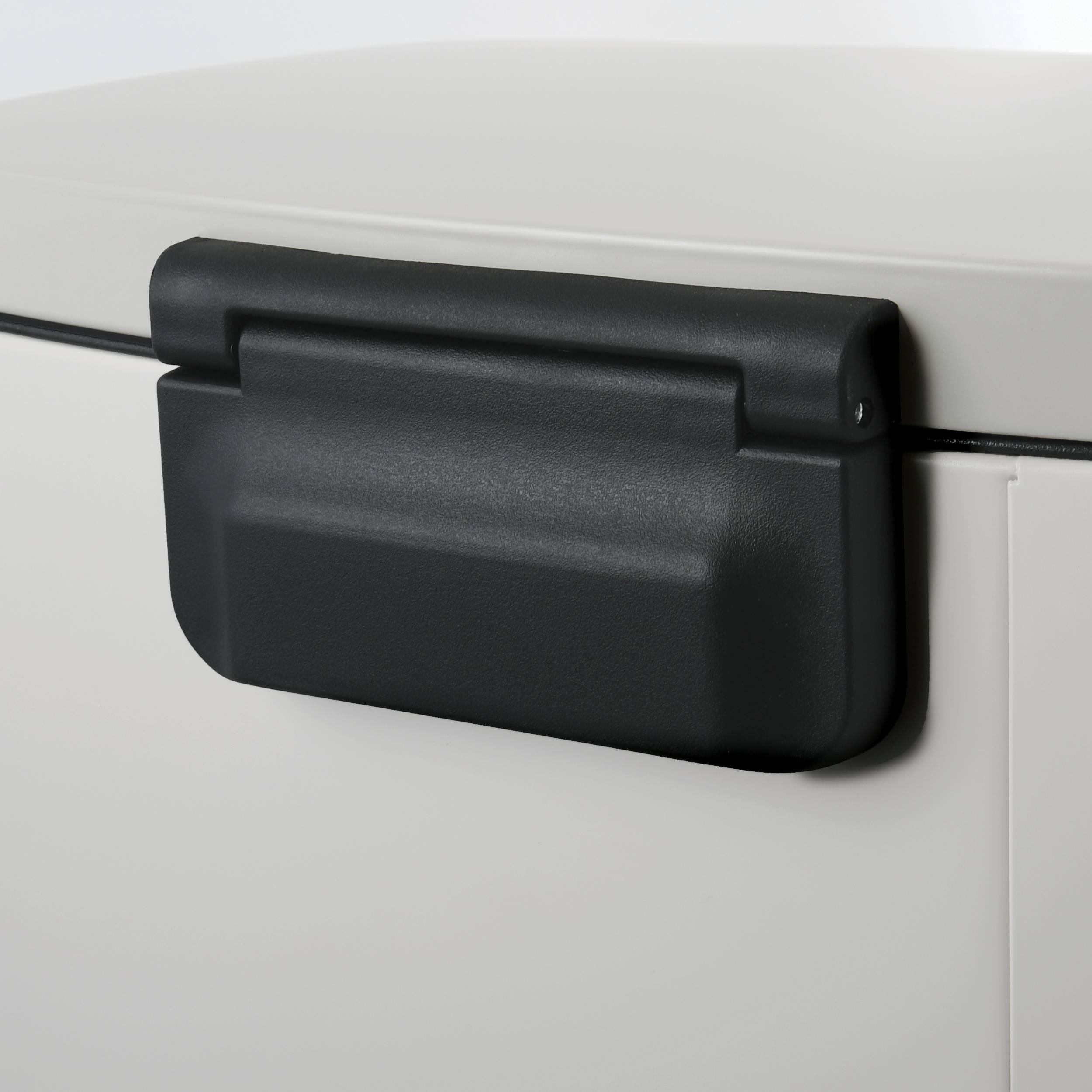 Schwarzer Kunststoff-Kabelorganizer, der über ein Kabel auf einem hellfarbigen Panel oder Schrank geclippt ist.