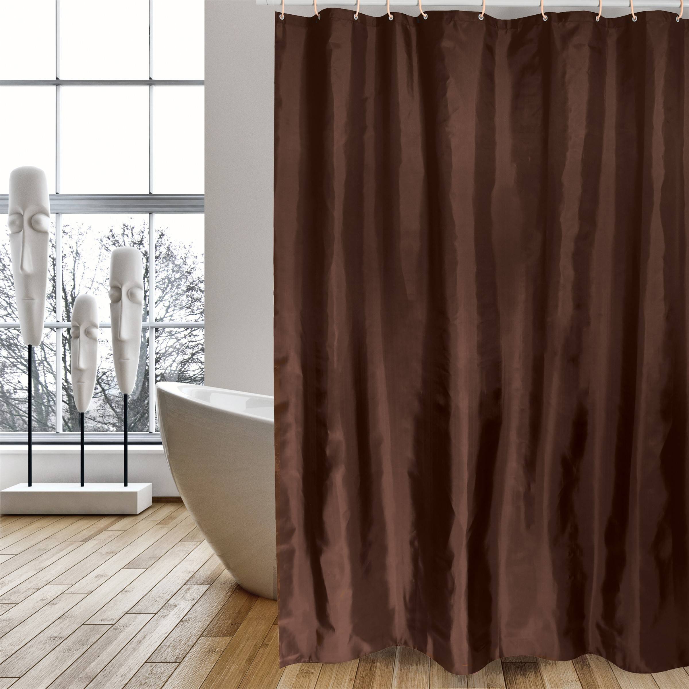 Ein brauner Vorhang verdeckt teilweise ein modernes Badezimmer mit einer freistehenden weißen Badewanne und einer skulpturalen weißen Bodenkunst neben einem großen Fenster.