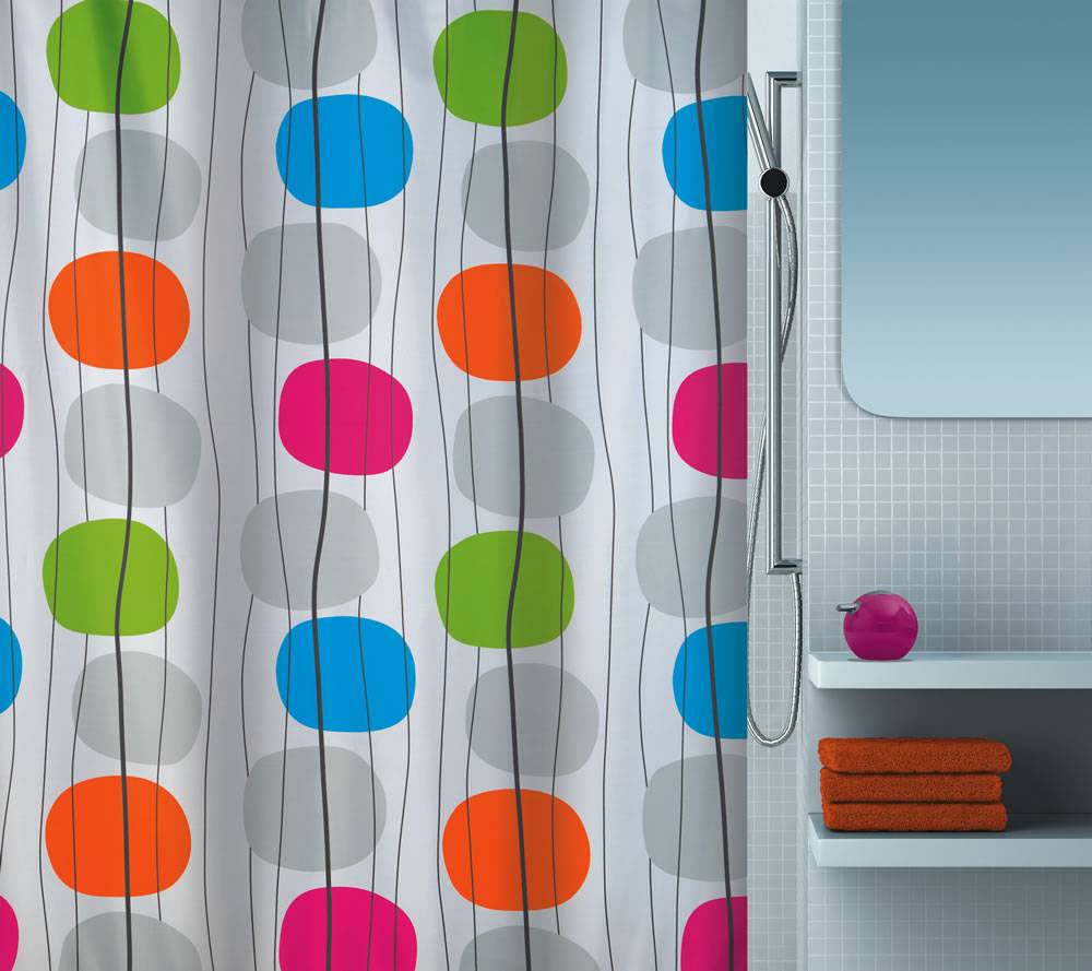 Badezimmer mit einem farbenfrohen gepunkteten Duschvorhang neben einem Duschregal, das gefaltete orangefarbene Handtücher und einen rosa Behälter hält.