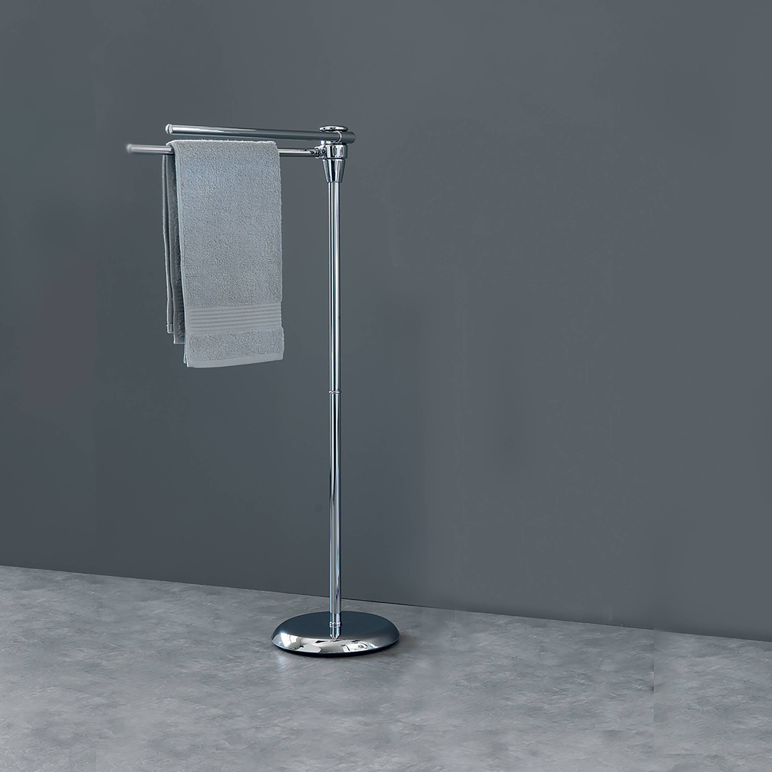 Glänzendes Handtuchgestell aus Chrom mit zwei grauen Handtüchern, die auf einem Ständer hängen, vor einer einfachen grauen Wand und einem grauen Boden.
