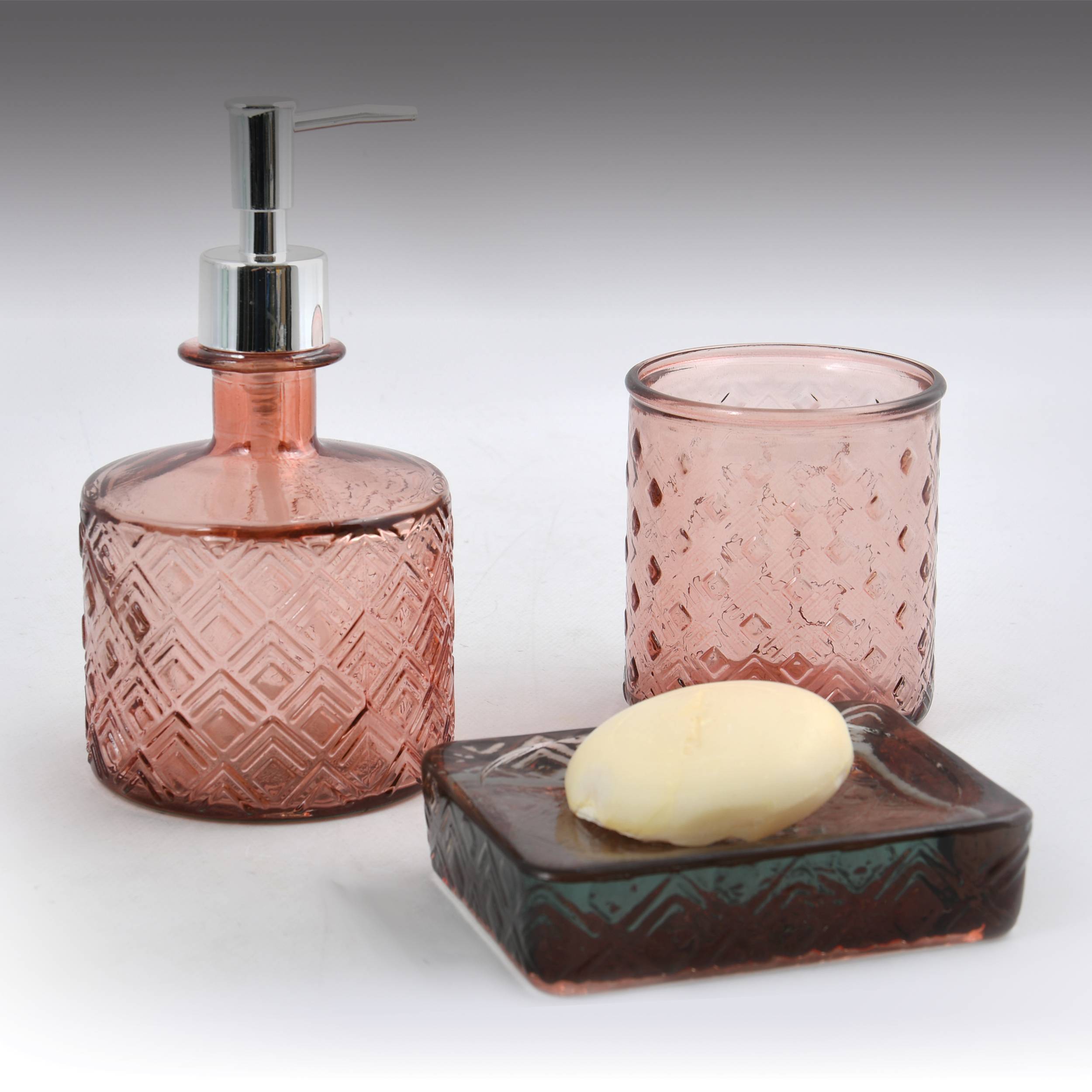 Rosa Glaseifentopf, Trinkglas und Seifenschale mit einem Stück Seife auf weißem Hintergrund.