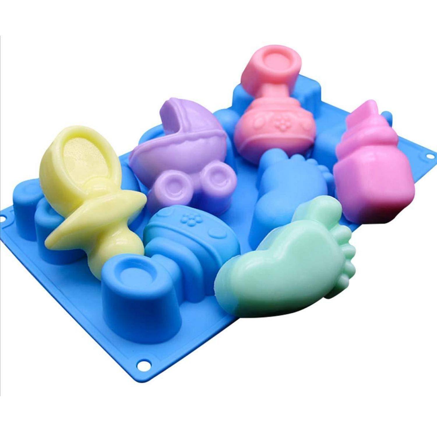 Bunte Silikonspielzeugformen auf einem blauen Tablett, geformt wie Babygegenstände und Flaschen, angeordnet auf weißem Hintergrund.