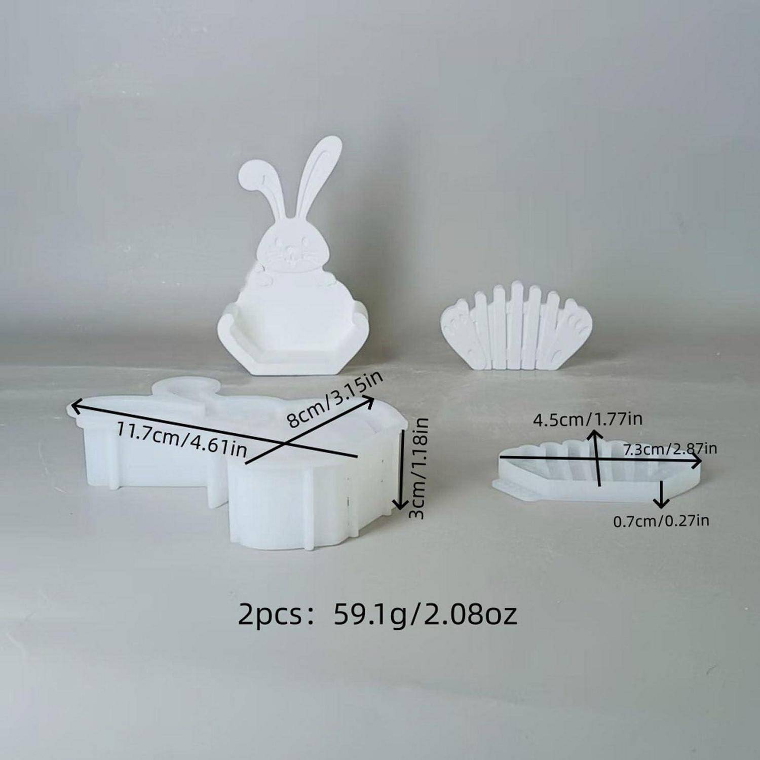 Weiße kaninchenförmige Eierbecher-Set mit eingeklappten und offenen Teilen, gezeigt mit Größenmessungen: 11,7 cm breit, 8 cm lang, 3 cm hoch; 7,3 cm lang, 4,5 cm breit, 0,7 cm dick; 2-teiliges Set, insgesamt 59,1 g.