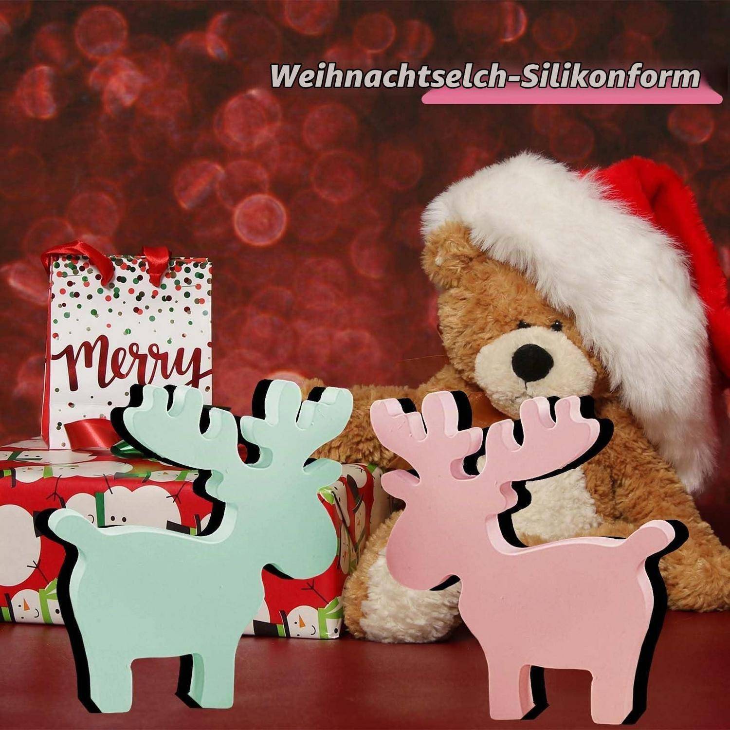Zwei pastellfarbene hirschförmige Weihnachtsdekoration stehen vor verpackten Geschenken und einem Teddy-Bären in einer Weihnachtsmütze, mit dem Text „Weihnachtselch-Silikonform