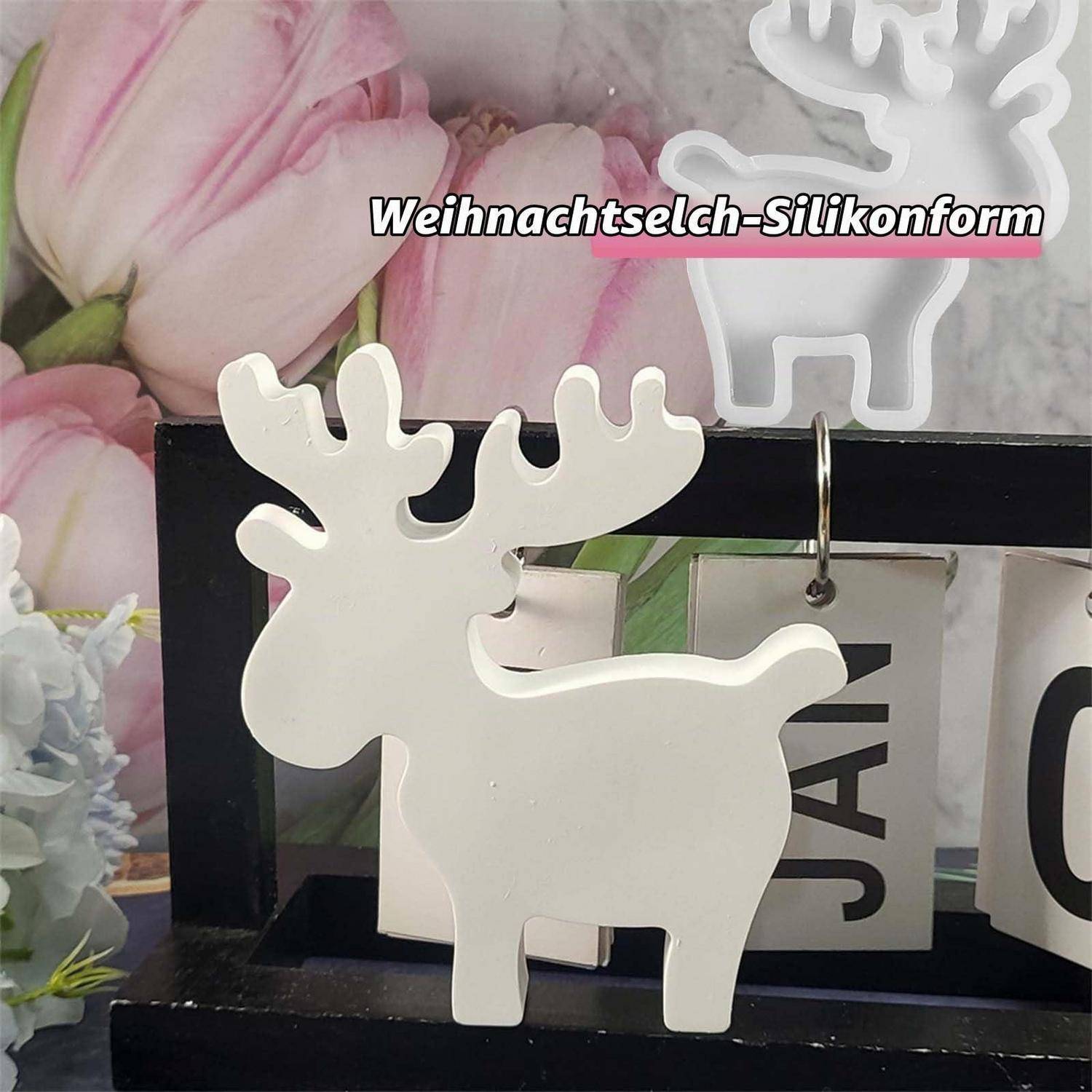 Weiße rentierförmige Silikonform oder Ornament auf einem dekorativen Tablett ausgestellt mit dem Text „Weihnachtselch-Silikonform