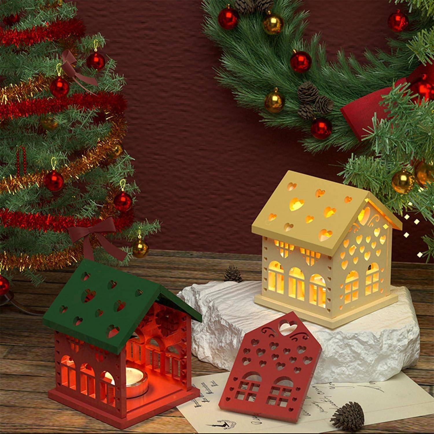 Festliche Dekoration mit drei dekorativen leuchtenden Laternenhäusern auf einer Holzoberfläche, eingerahmt von Weihnachtsgirlanden und Schmuckstücken.