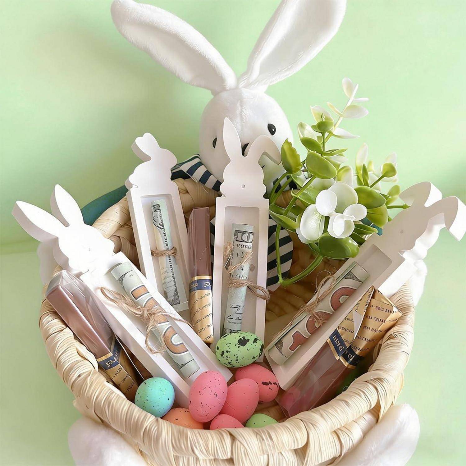 Osterkorb in Hasenform gefüllt mit zusammengerolltem Geld, Makeup-Artikeln, Pastelleiern und Blumen auf hellgrünem Hintergrund.