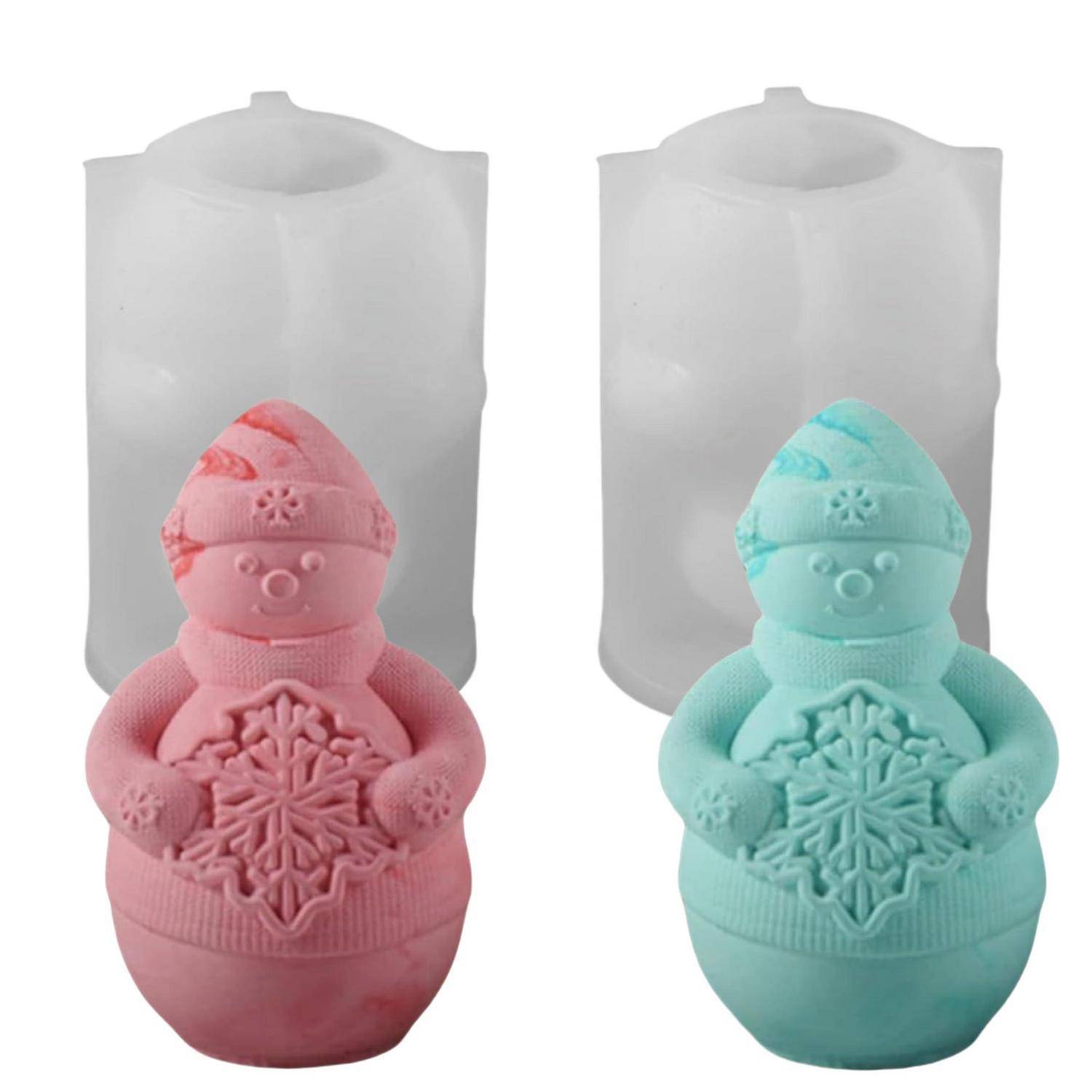 Zwei Schneemann-förmige Kerzen, eine rosa und eine minzgrün, vor ihren durchscheinenden grauen Formen gezeigt.