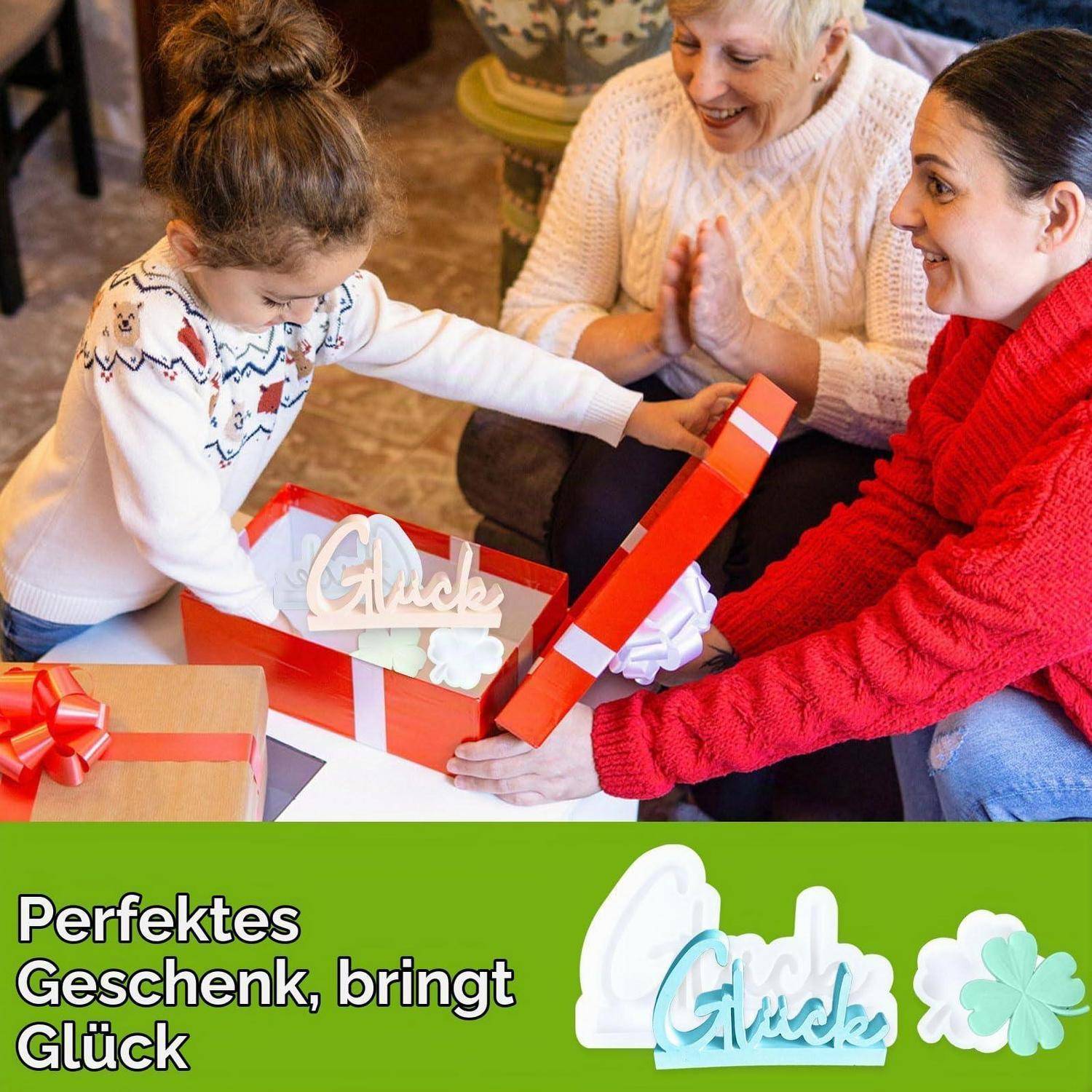 Frau und Kind öffnen eine Geschenkbox mit dem Wort „Glück"; der Anzeigentext lautet „Perfektes Geschenk, bringt Glück"" neben einer Kleeblatt-Grafik.