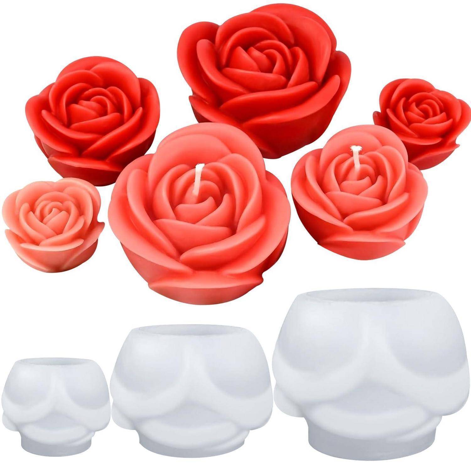 Set aus rosenförmigen roten und rosa Kerzen über drei weiße schädelförmige Kerzenhalter auf weißem Hintergrund.